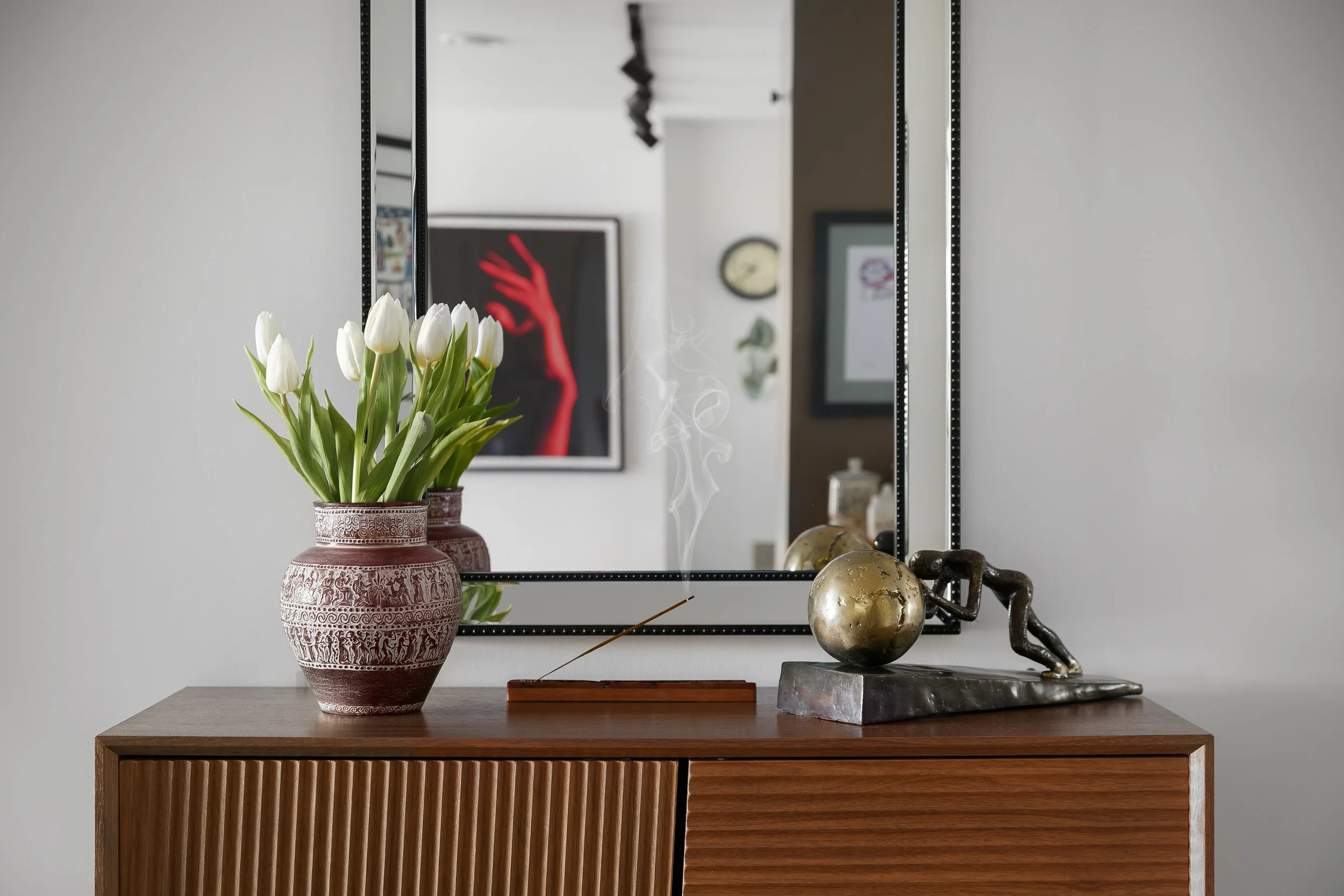 Vintage sideboard with floral arrangement and mirror, eclectic living space styling by Rodolfo Falcao, Bow East London