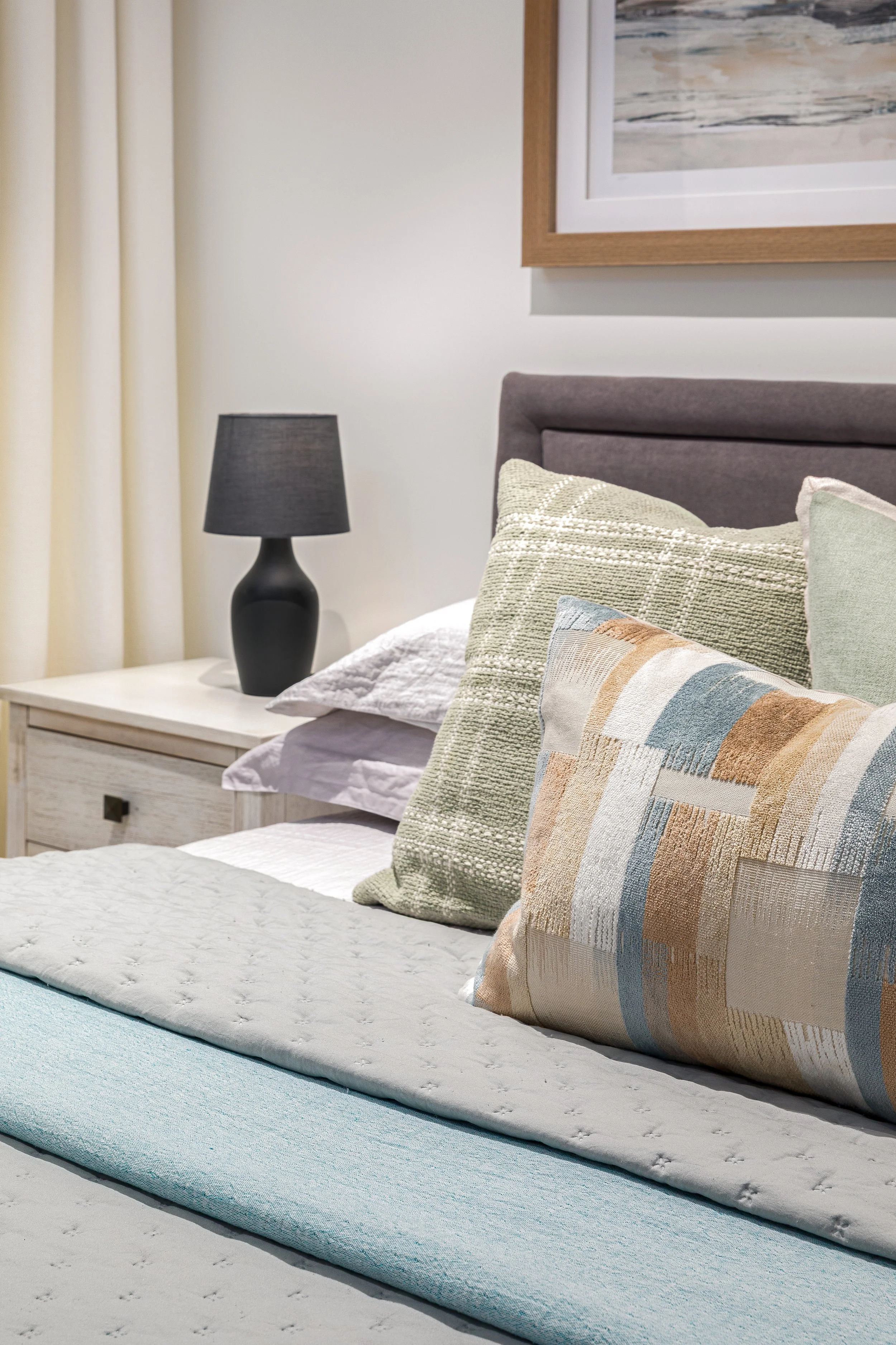 Bedroom detail with teal and rust cushions on grey upholstered headboard, Limehouse Cut London by Rodolfo Falcao