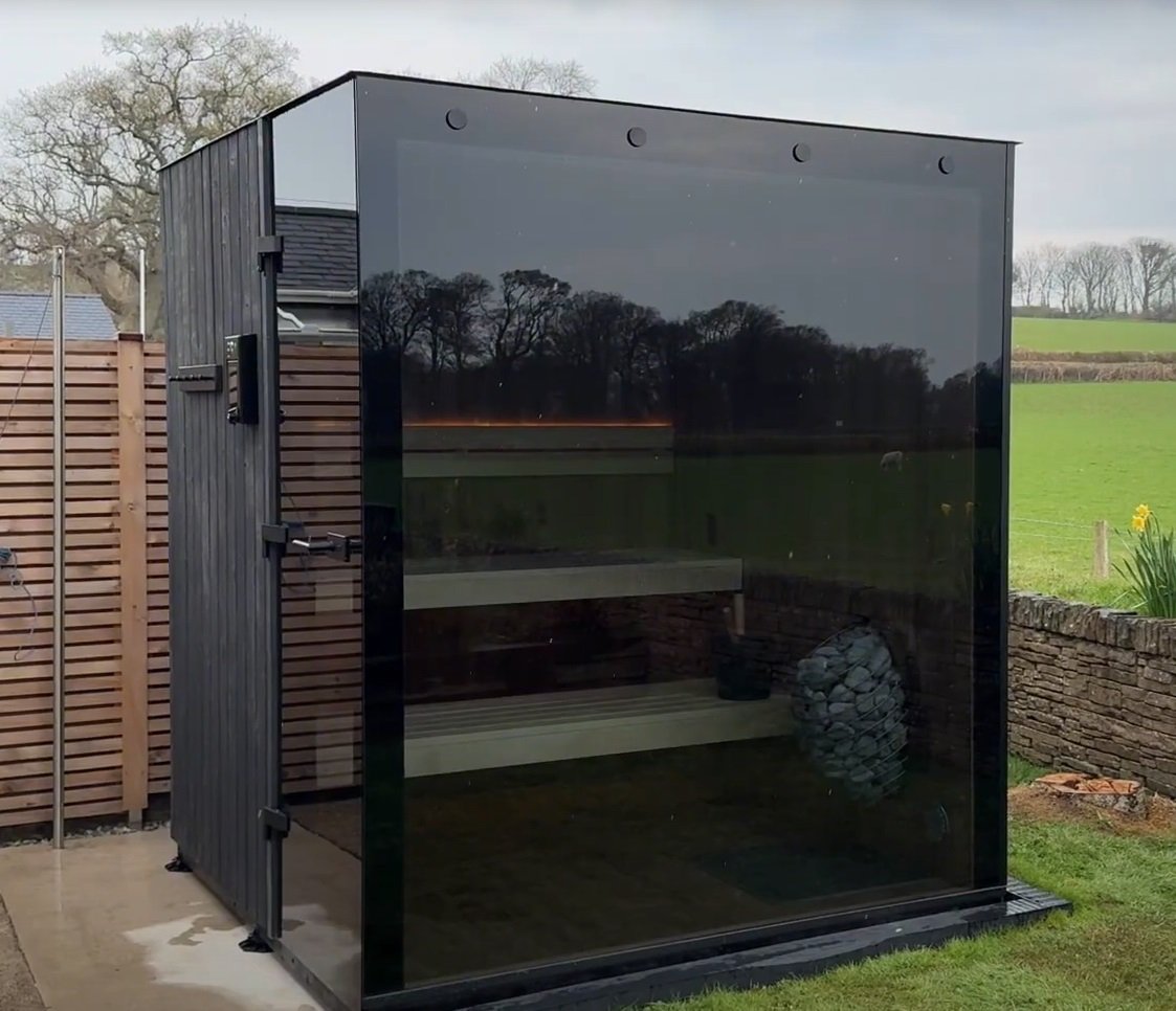 A small outdoor sauna or shower enclosure with a black glass front. Order yours and improve your health by tomorrow.