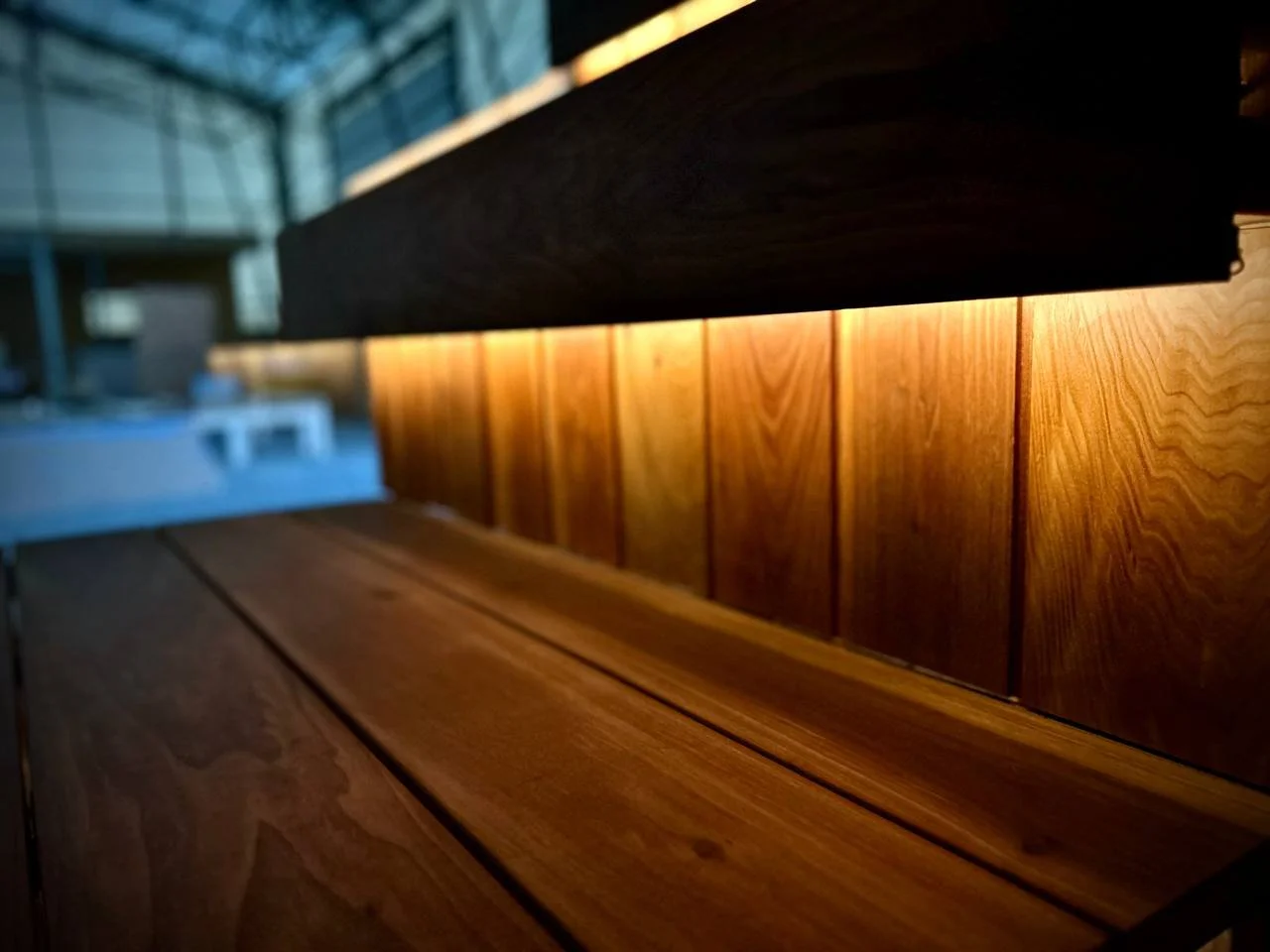 Close-up of wooden panels with a warm backlight, showing the grain and texture of the wood.