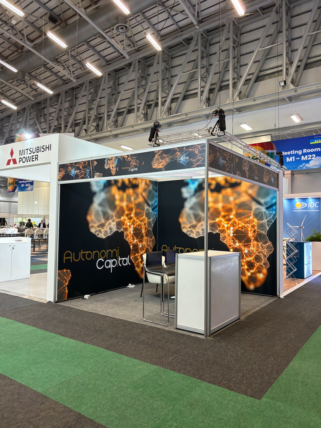 A conference booth for Autonomi Capital with digital graphics of interconnected nodes, located inside a large exhibition hall. Cape Town, South Africa.