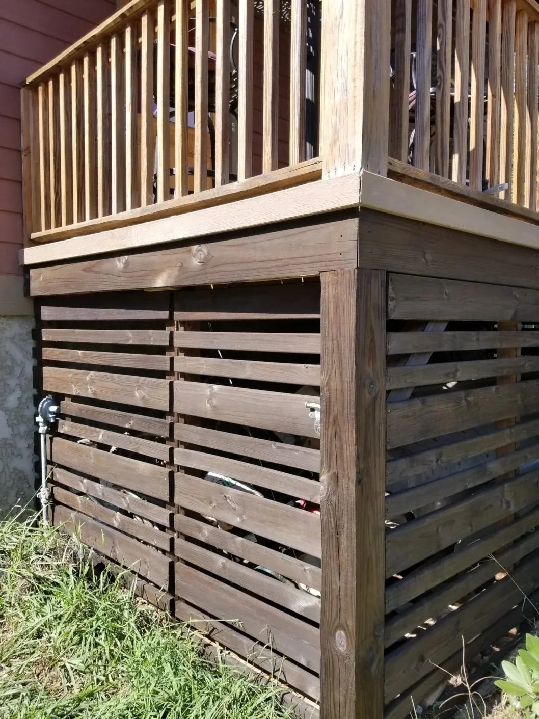 Close-up of a wooden deck railing and lattice skirting on a house.