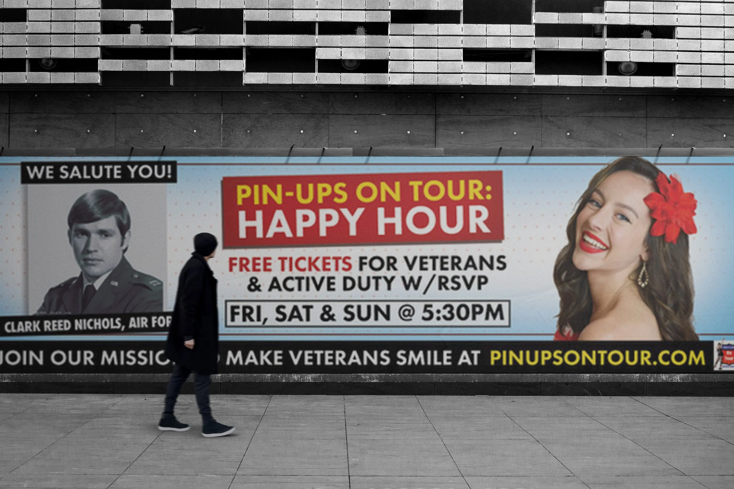 Man walking by large advertisement for pin ups on tour