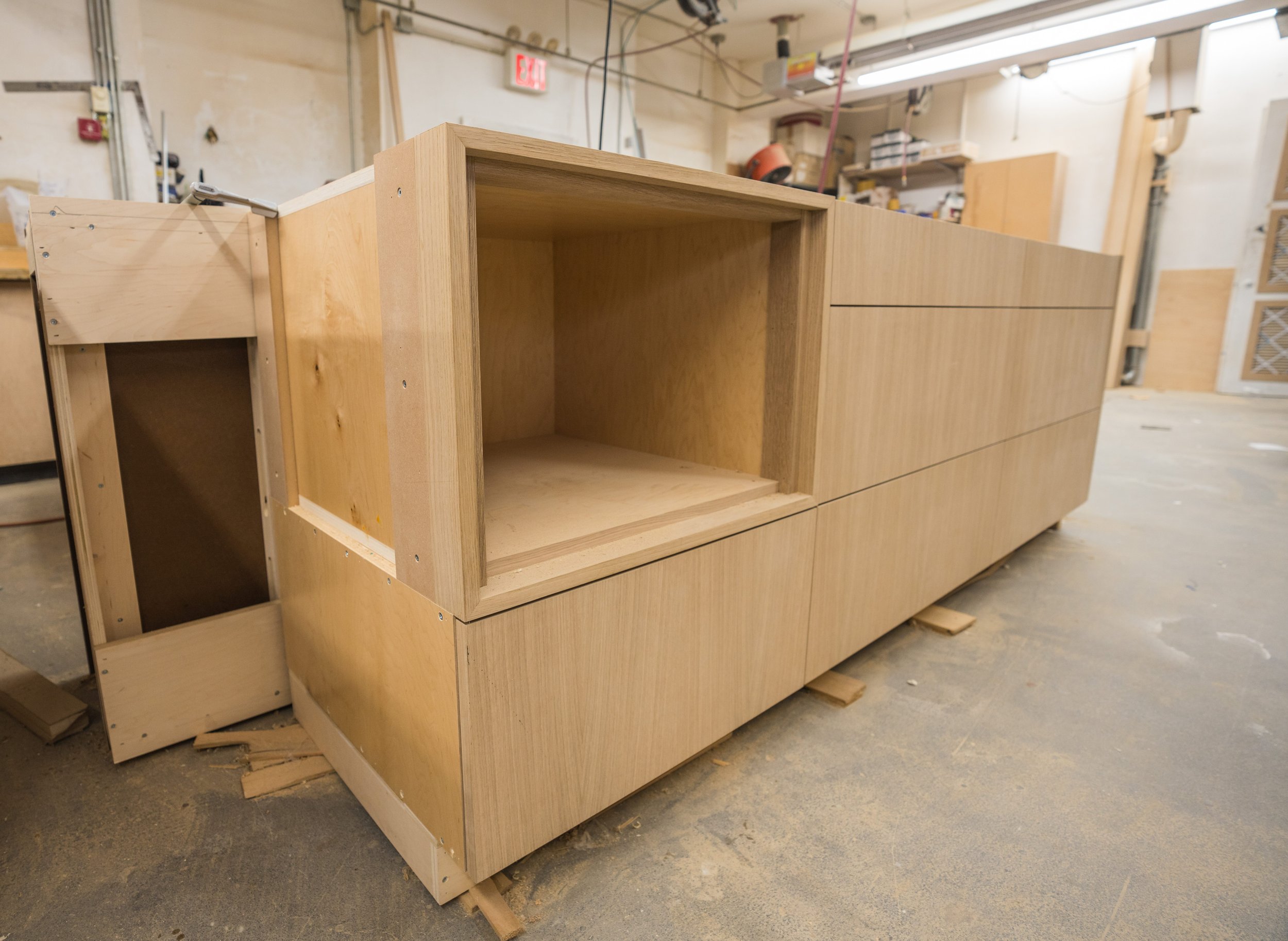 Unfinished wooden cabinet in a workshop under construction.