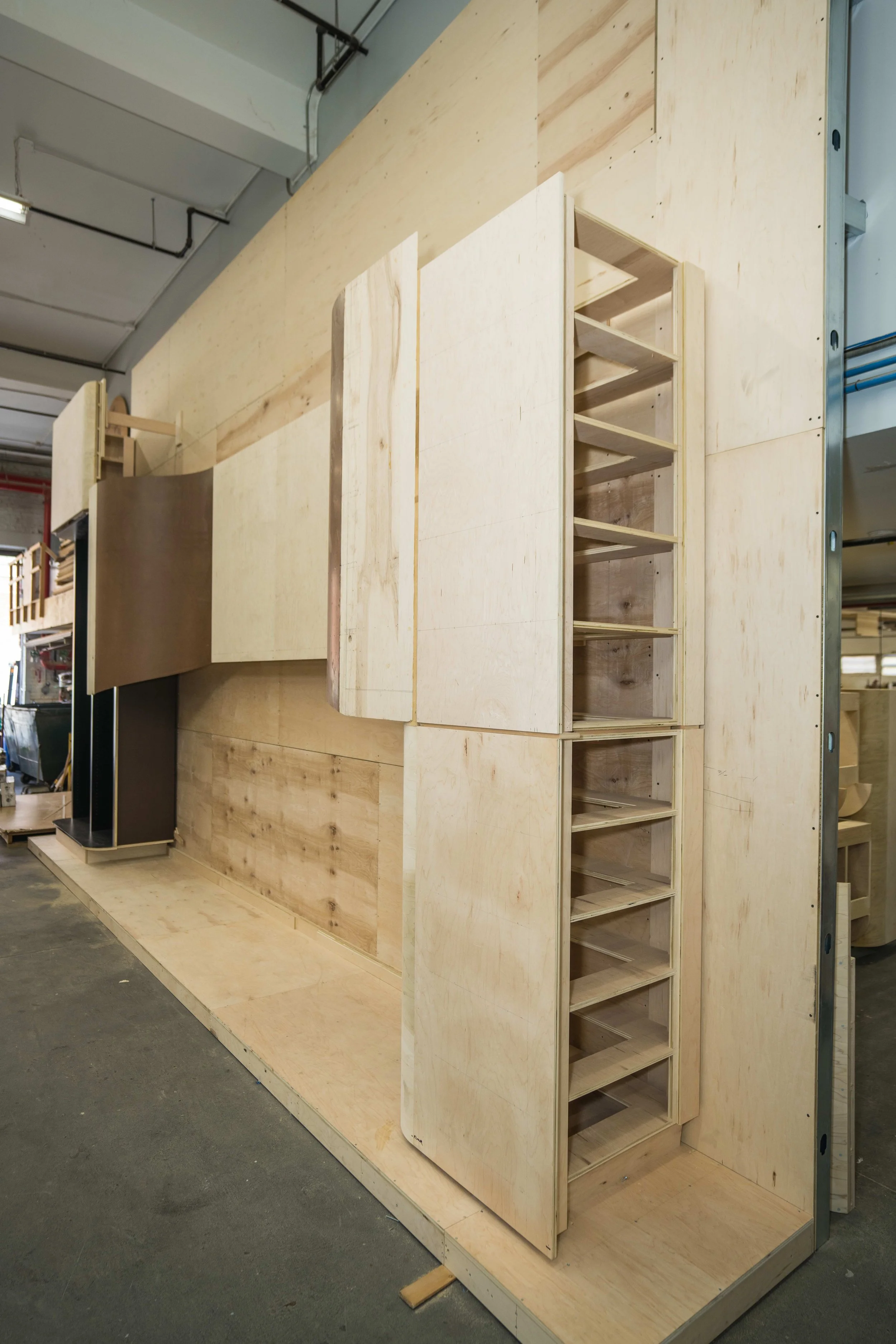Unfinished wooden staircase and wall structure in a workshop or construction site.