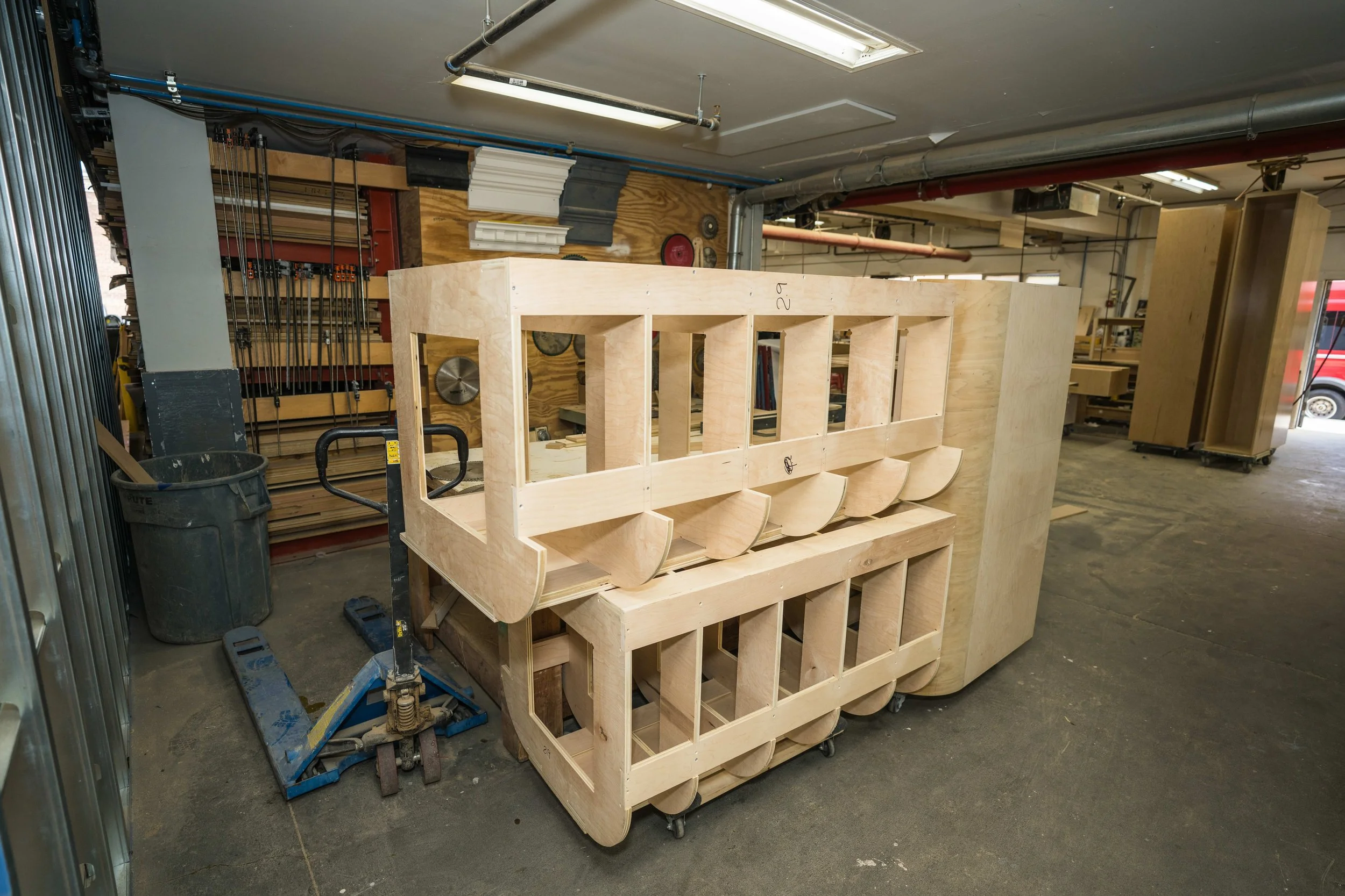 Woodworking workshop with unfinished wooden structure, various tools, and materials for carpentry work.