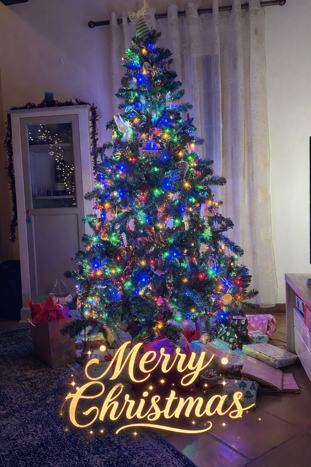 Christmas tree with colorful lights, ornaments, garland, and presents at French House La Tour Blanche