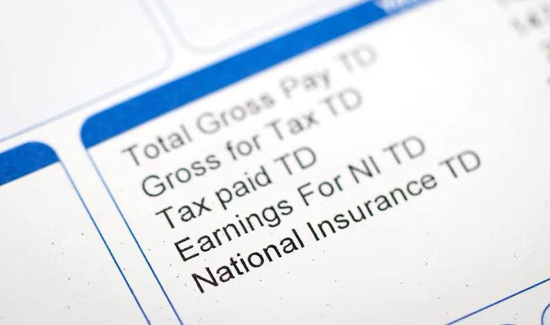 Close-up of a tax document or form showing details for gross pay, tax paid, earnings, and national insurance.