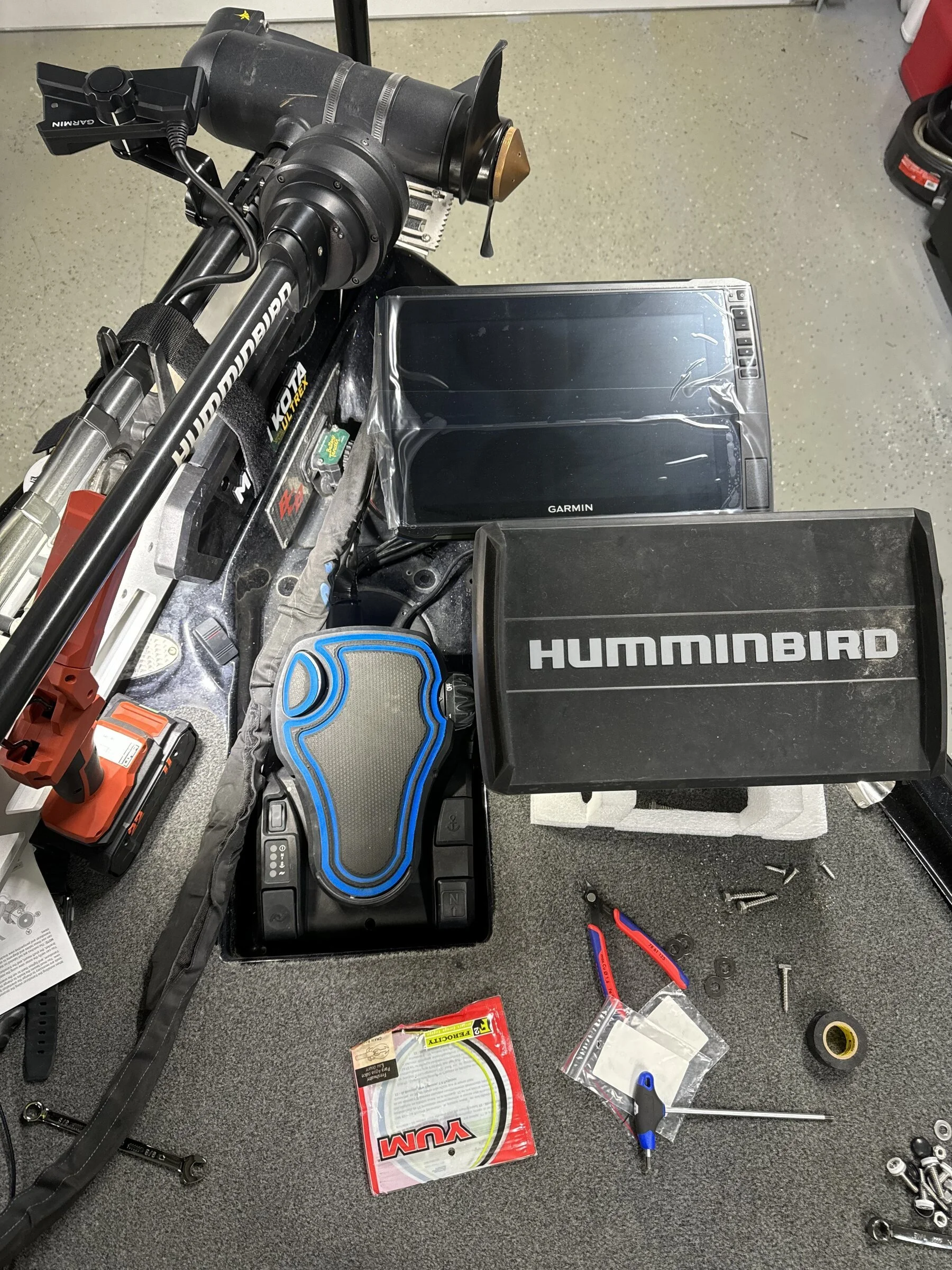 Trolling motor, sonar units, and rigging tools laid out during a full electronics installation