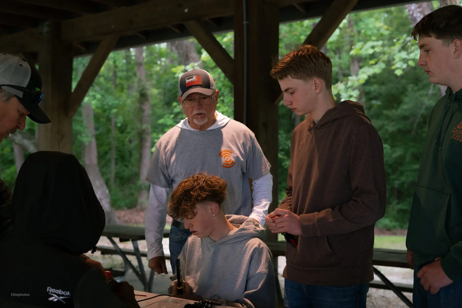 Kids and a Waypoint Marine Technologies instructor gathered around a table at Junior Marine Tech Day