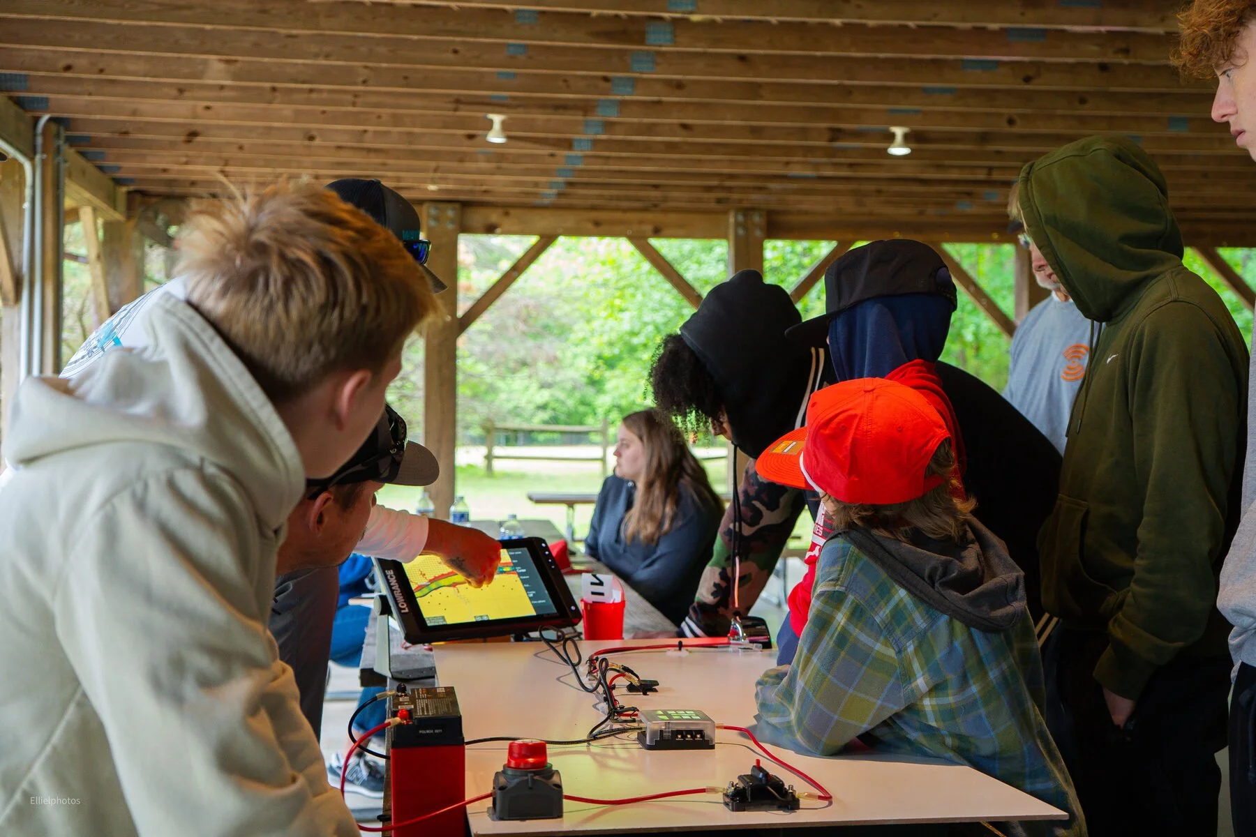 Kids gathered around a Lowrance chart plotter at Junior Marine Tech Day