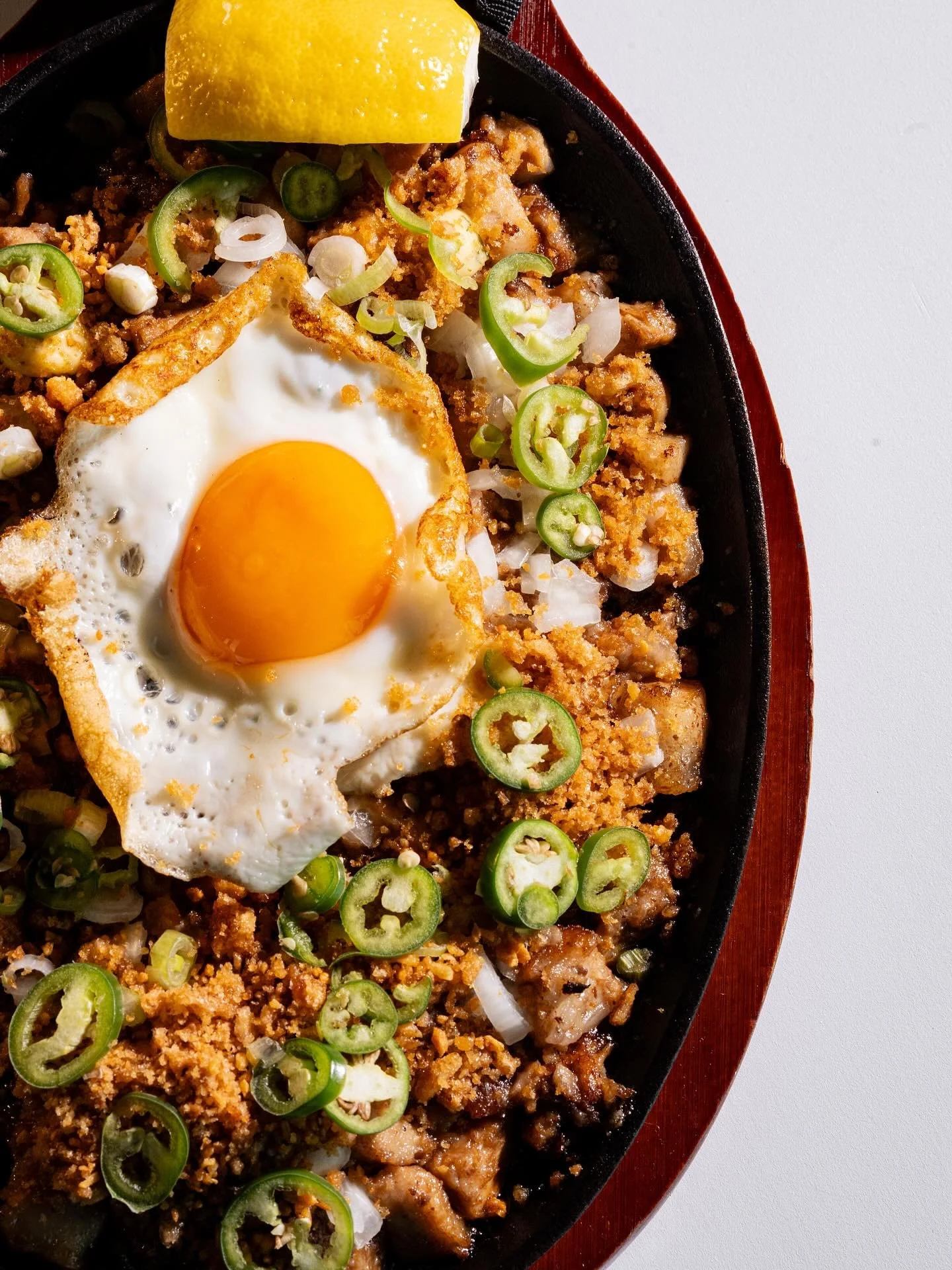Sizzling Sisig! 🇵🇭

Crispy pork belly, jowl, and ears tossed with chicken liver paste, sweet onions, and serrano peppers!

📸 @jgageproductions 

#Notyourkapampanganstyle #CrispySisig #FilipinoPulutan #Bulakenya #filipinocuisine #chicharon