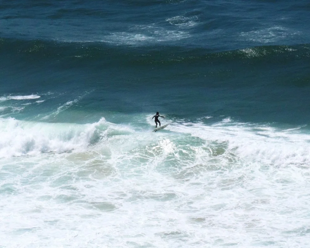 A person surfing on a wave in the ocean.