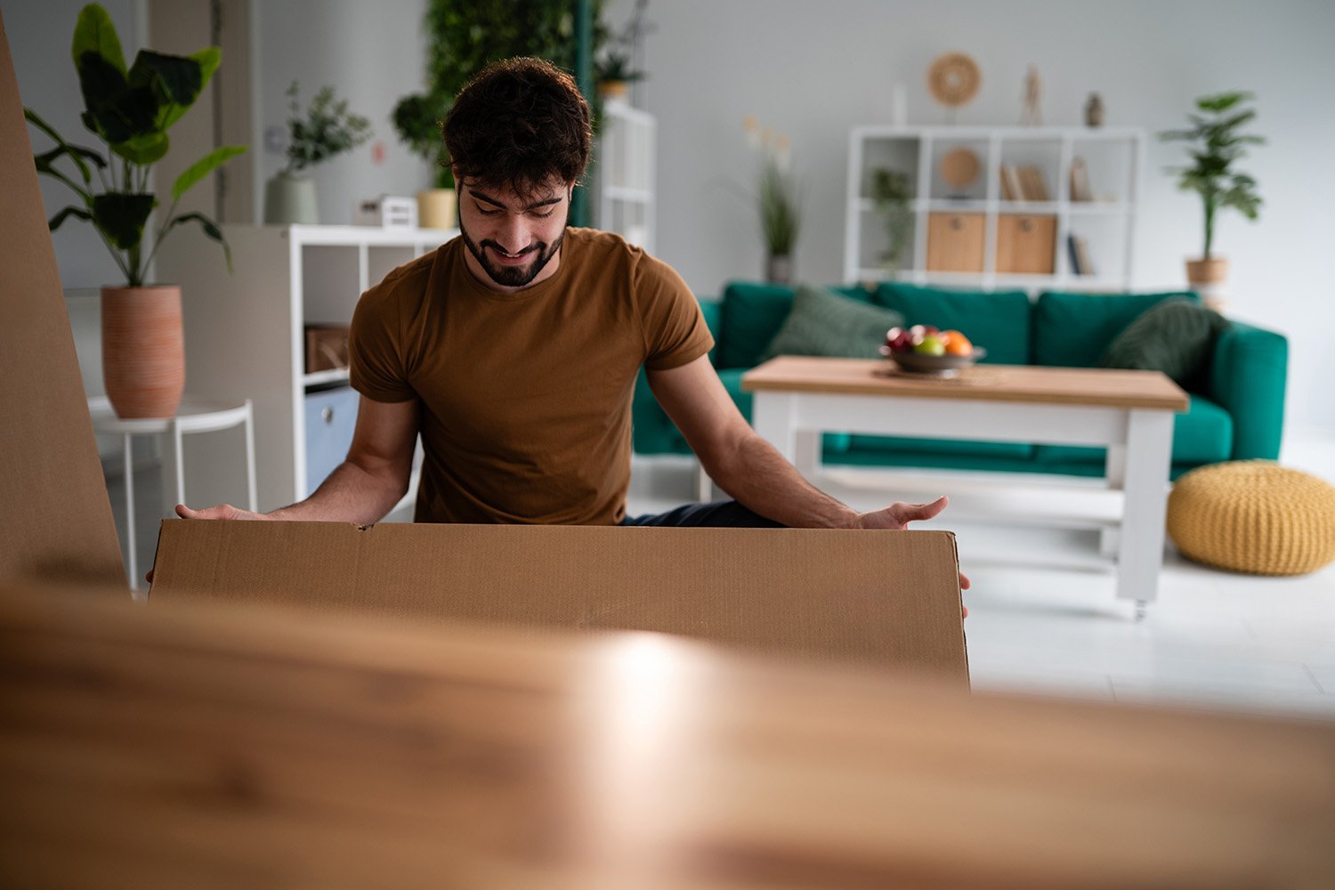 Man moving boxing into living room
