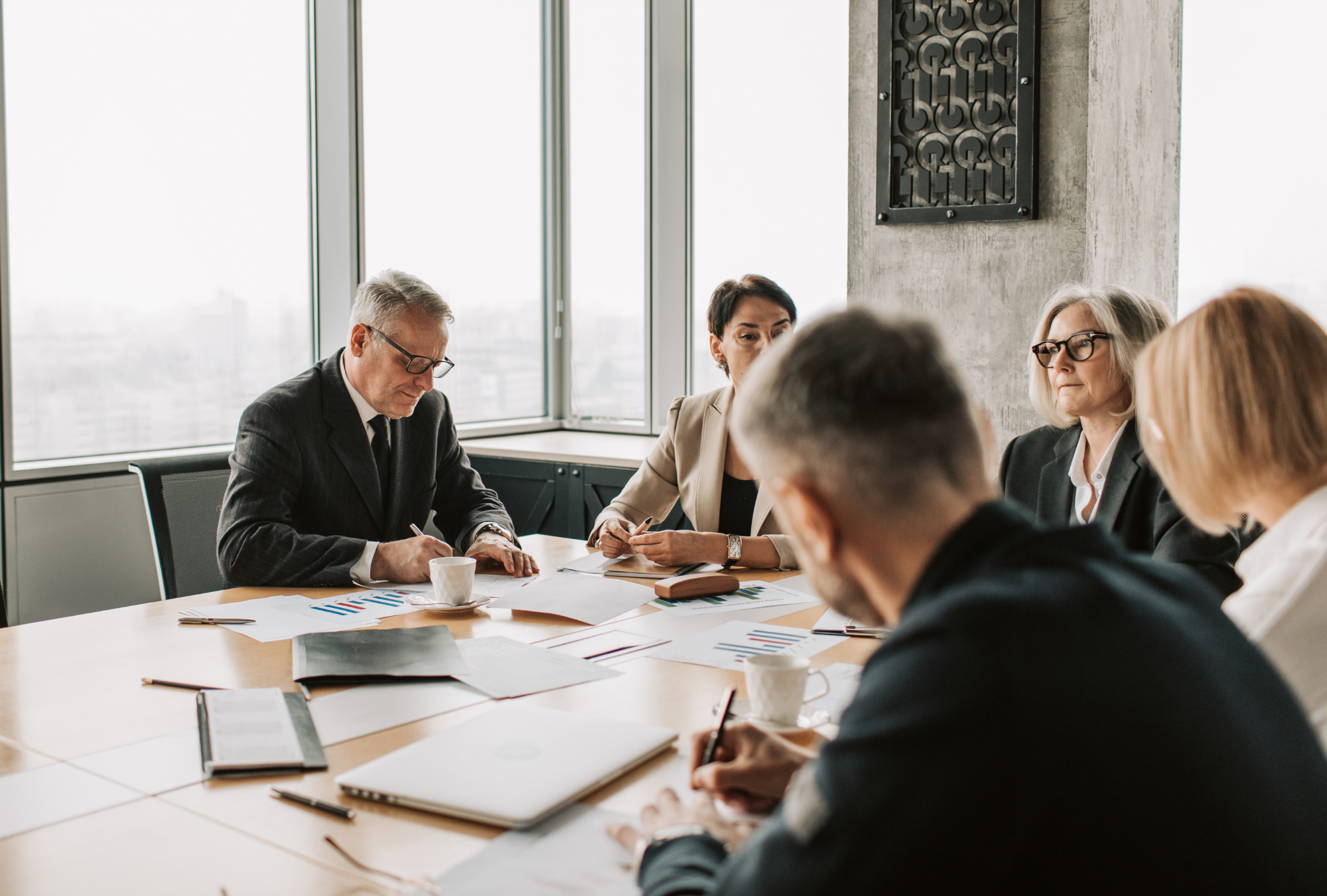 Estate planning attorneys reviewing legal documents with clients in a law firm boardroom meeting