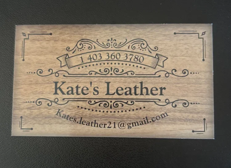 Wooden business card for Kate's Leather with contact info and email.