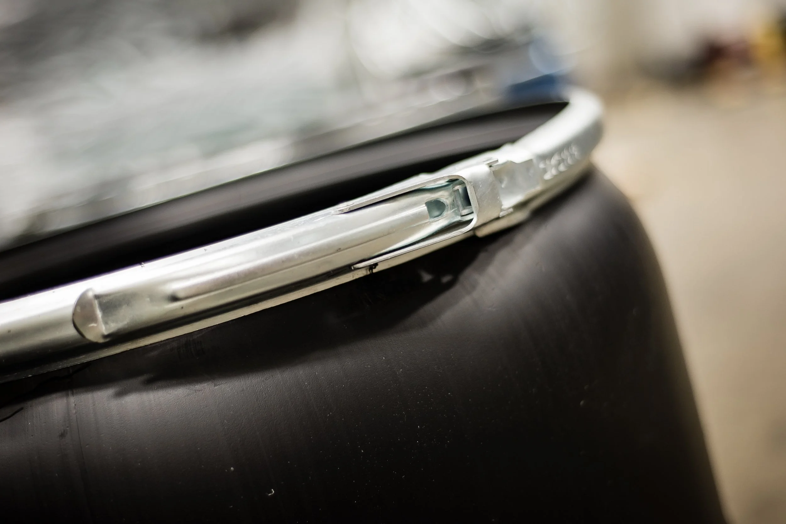 Close-up of a damaged silver car door handle on a black car.