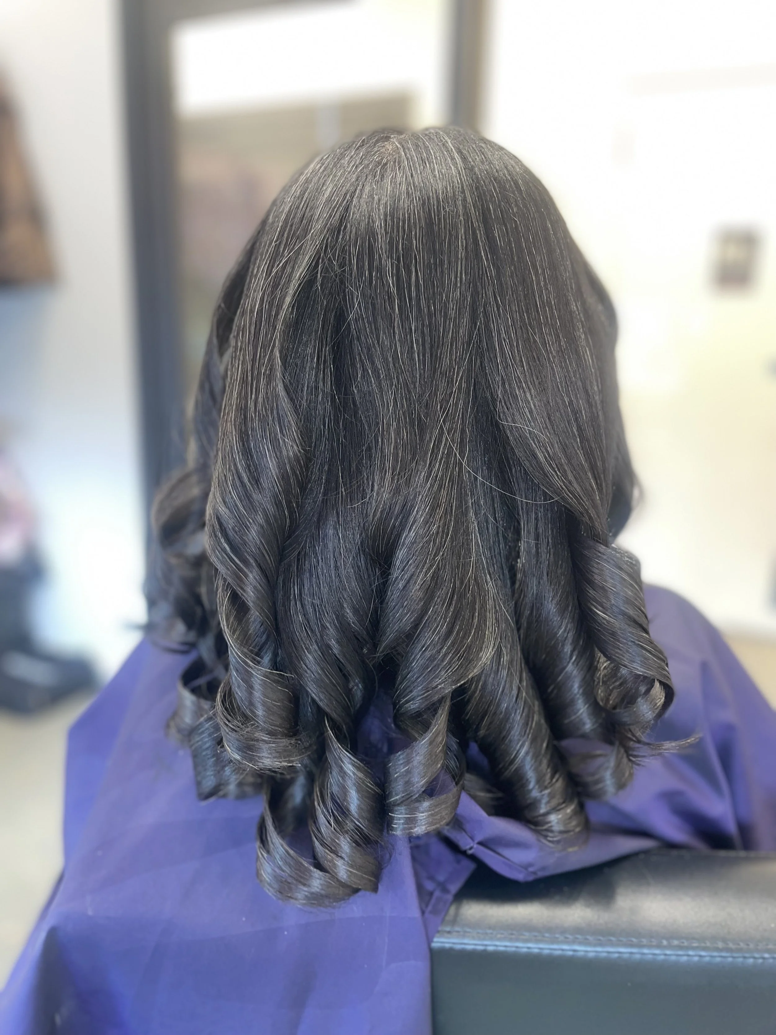 Silk press on textured hair featuring smooth, polished curls and healthy shine.