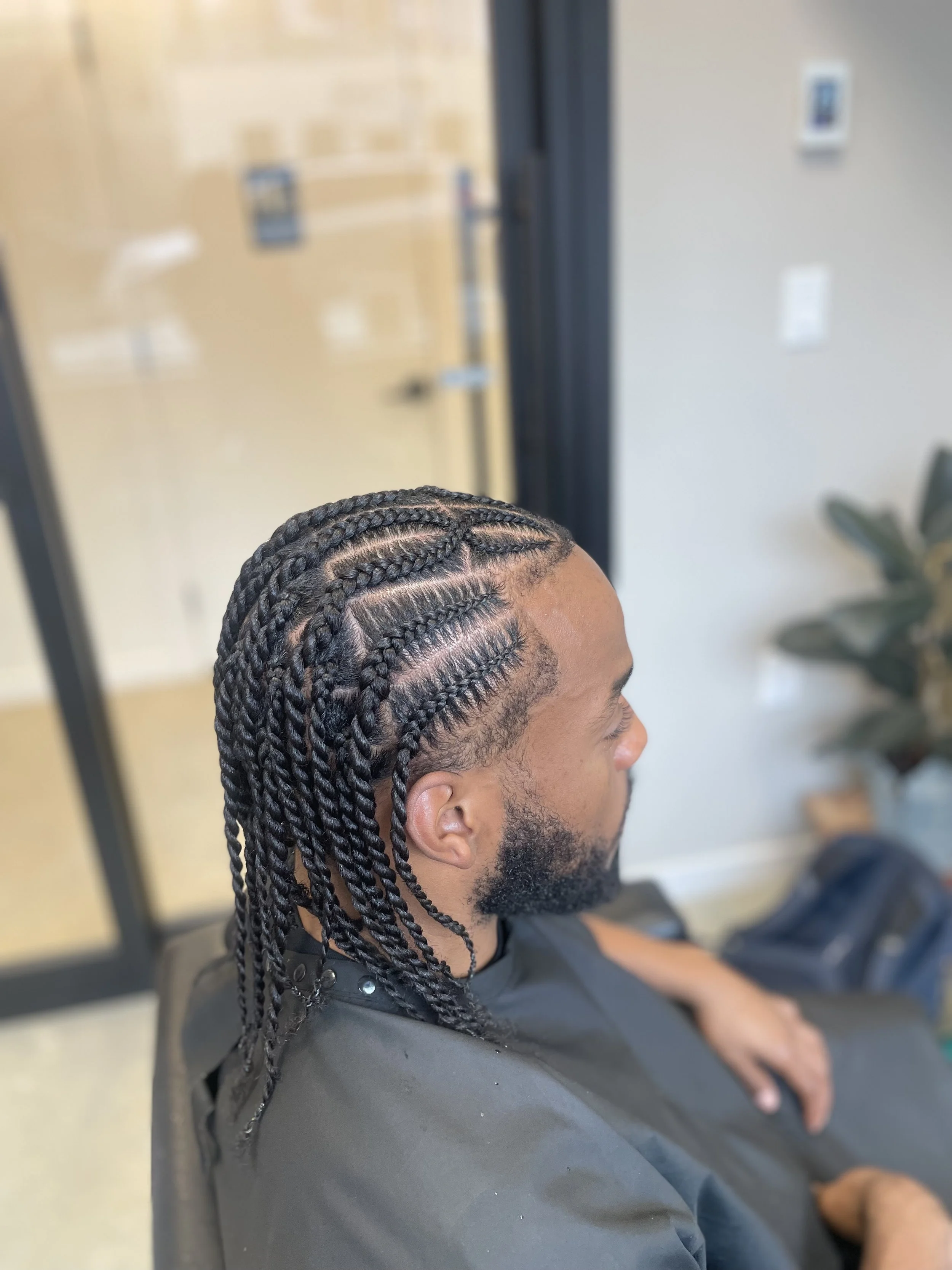 Corporate man with a straight back stitch braid style completed in the private salon studio at Fantasy Tresses Brooklyn.