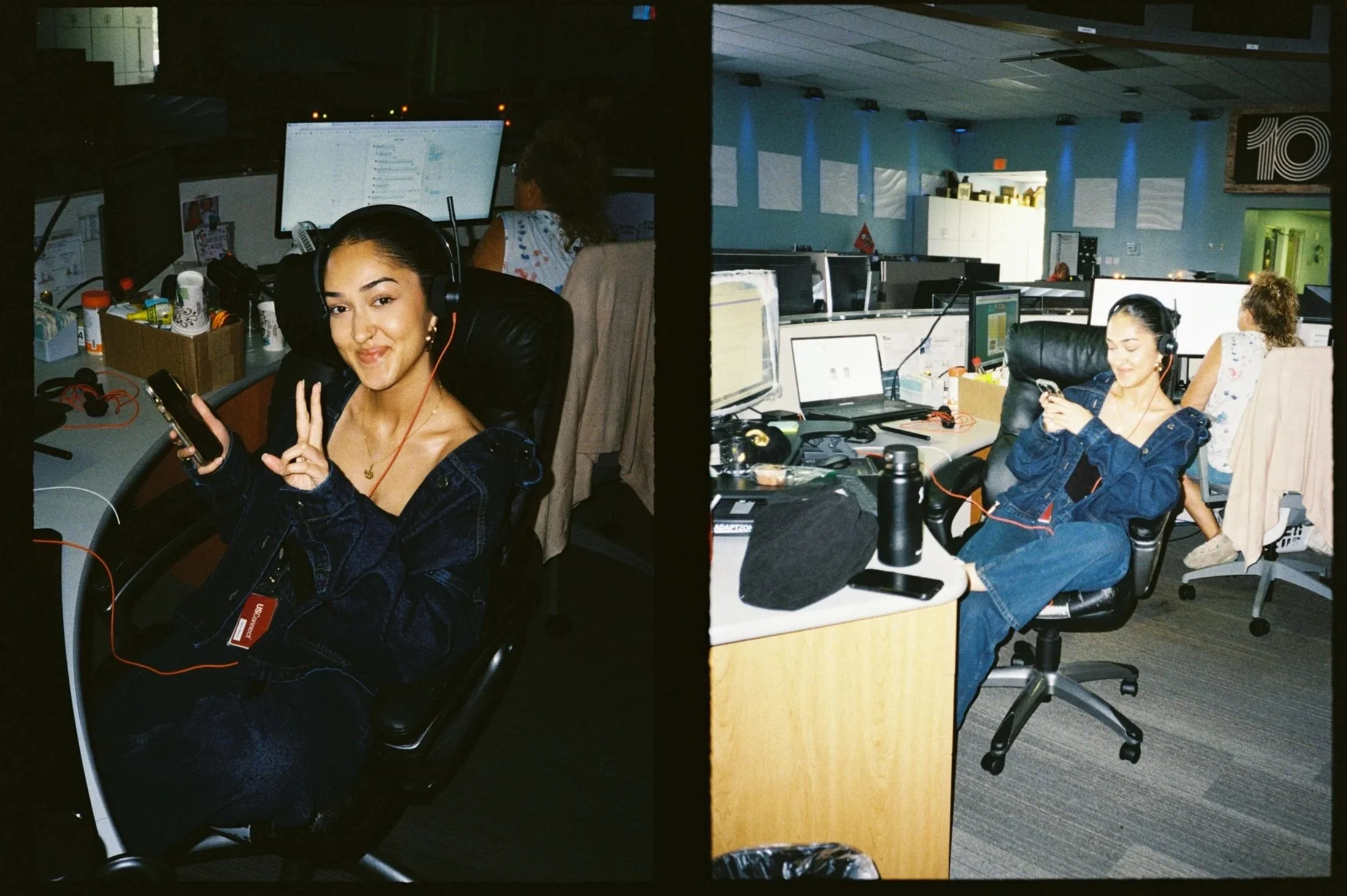 A young woman in a dark denim jacket and headphones, sitting at a workstation in an office, making a peace sign and smiling at the camera.