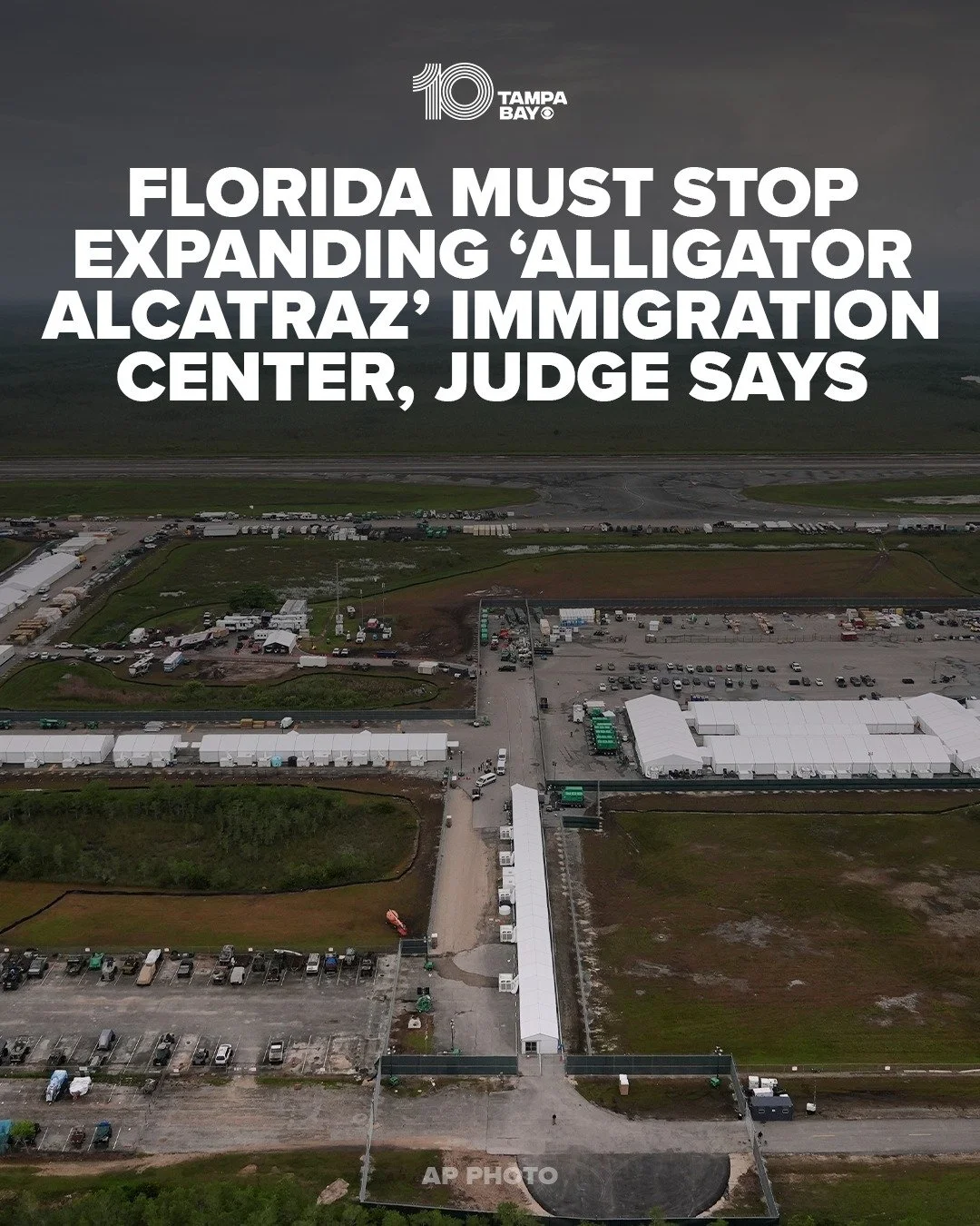 Aerial view of a large immigration processing center with tents, vehicles, and structures, overlaid with a headline about Florida's opposition to expansion of the Alligator Alcatraz immigration detention center.