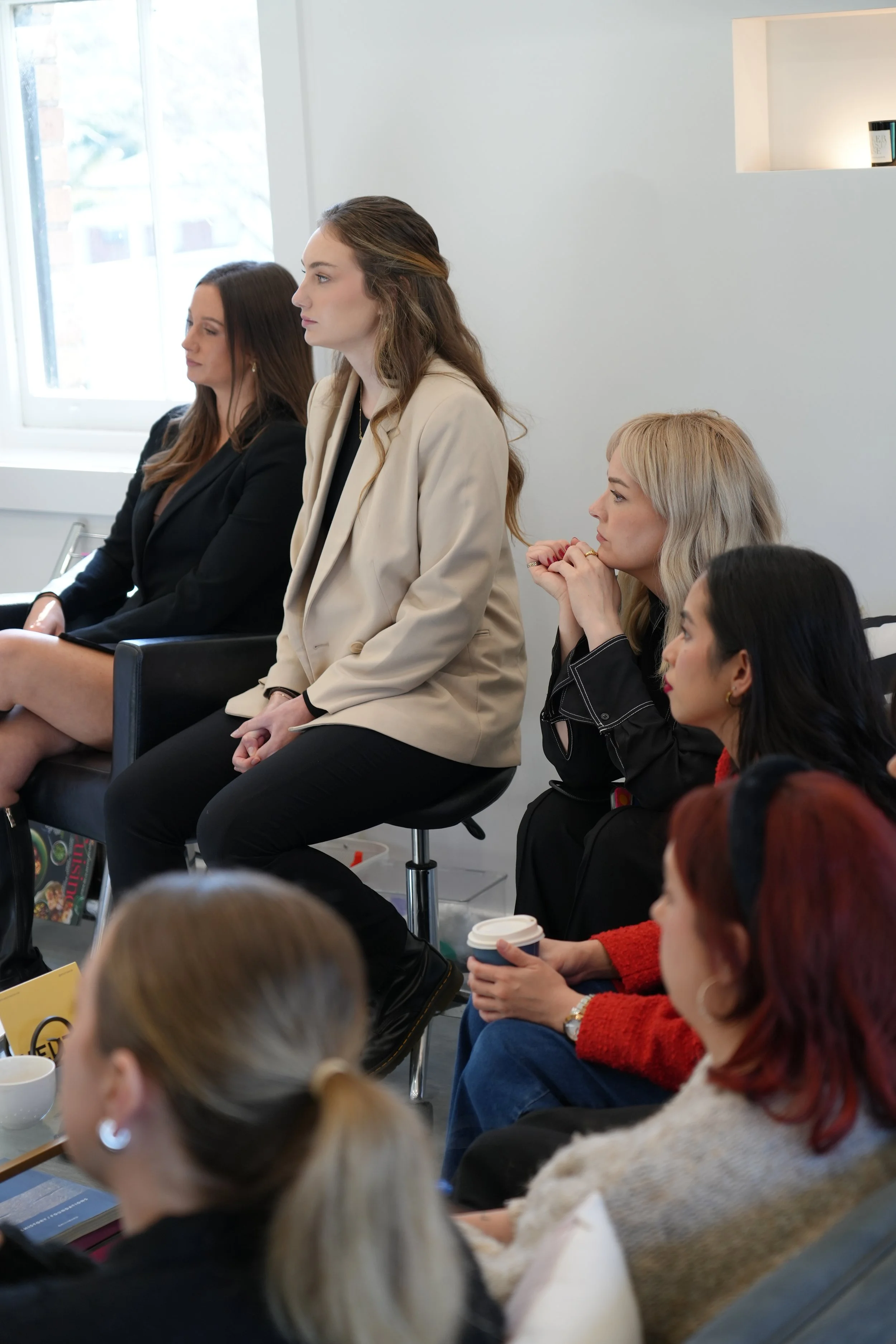 Women attending a meeting or seminar, sitting attentively and listening.