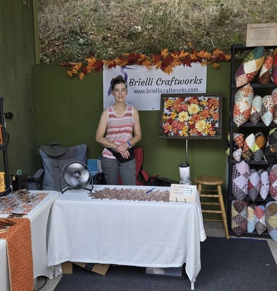 Kelli Clark in front of a Brielli Craftworks banner at our first craft fair.