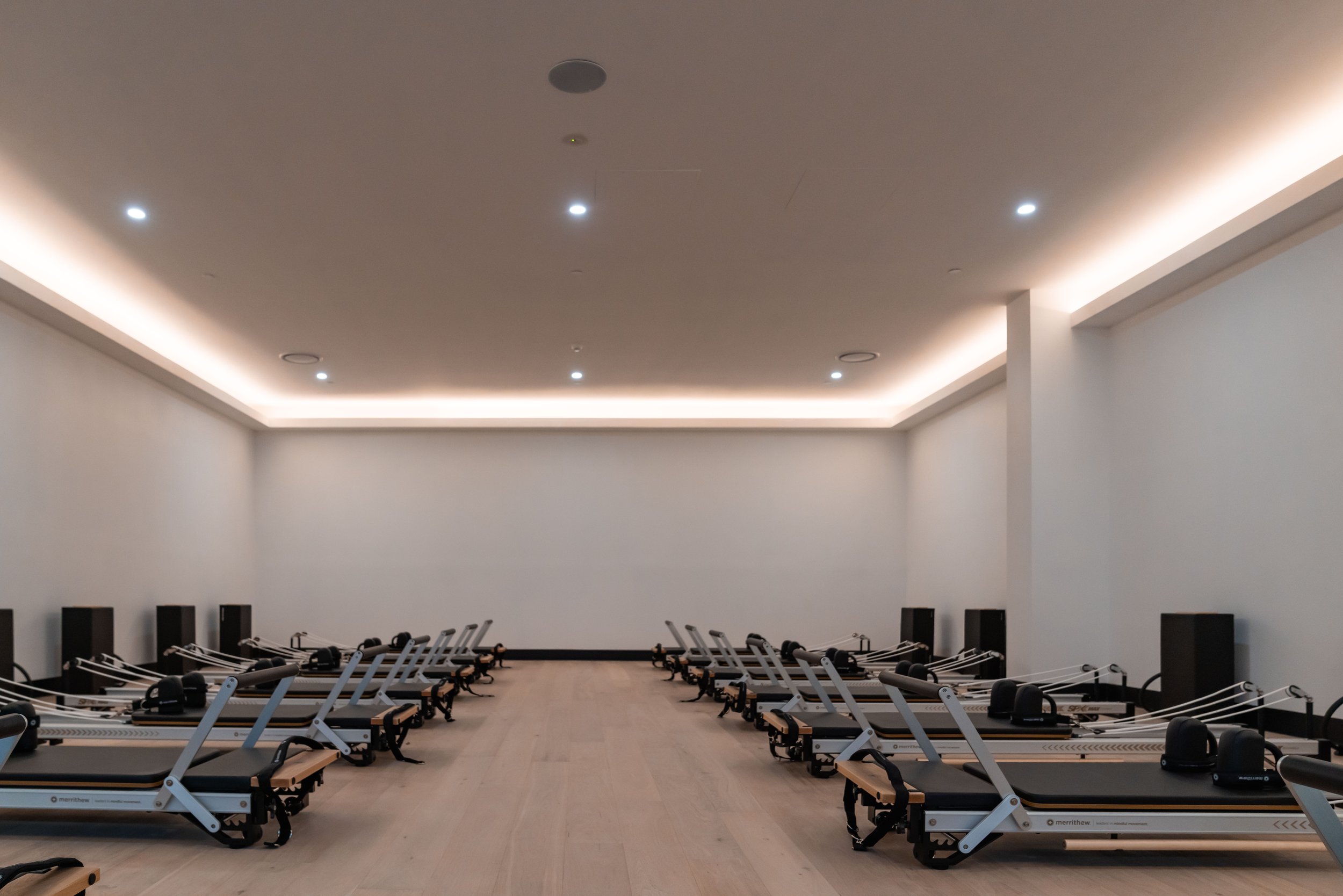 Reformer Pilates studio with rows of reformer machines and a minimalistic design.