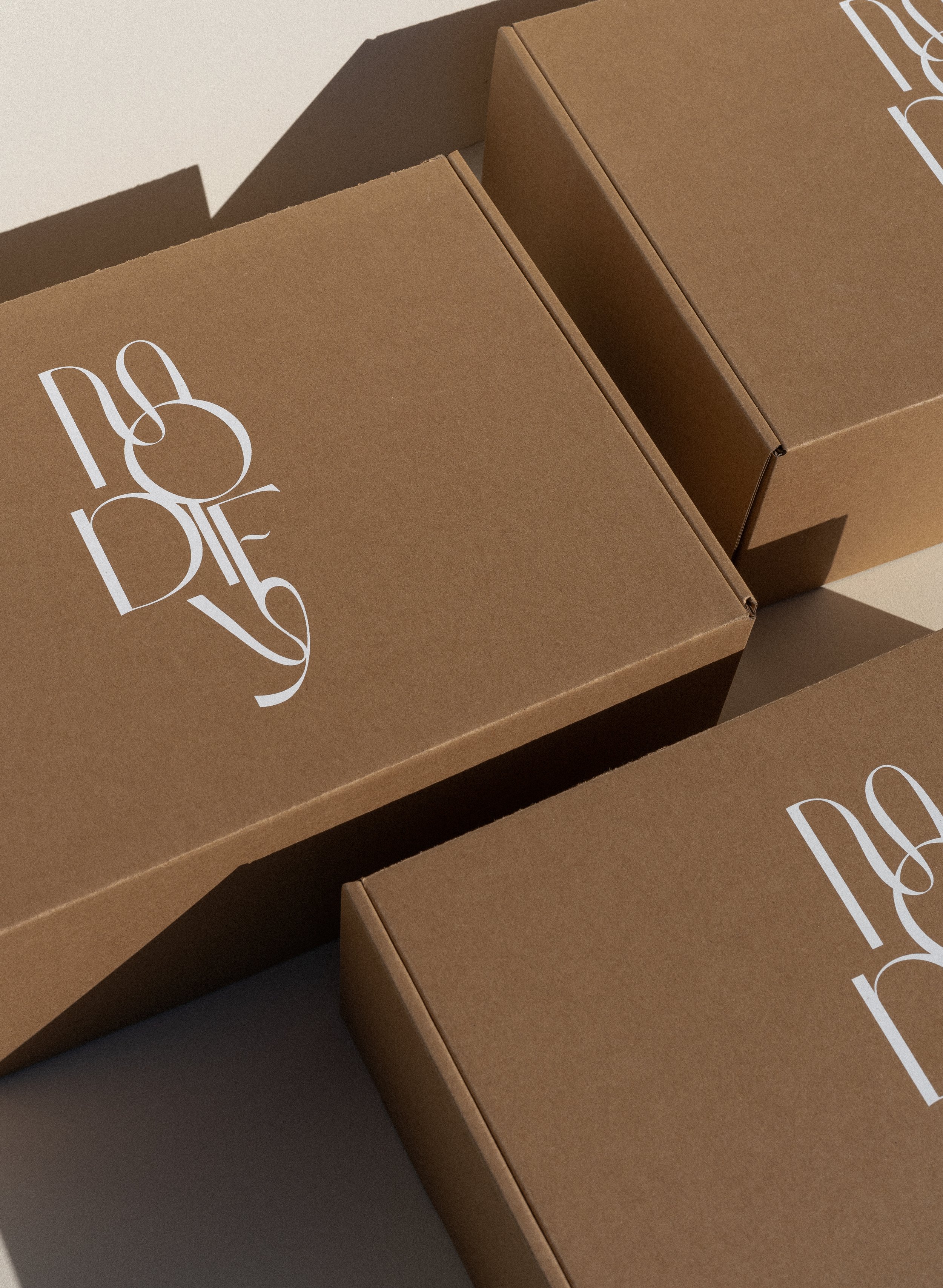 Three brown cardboard boxes with white printed text on the top.