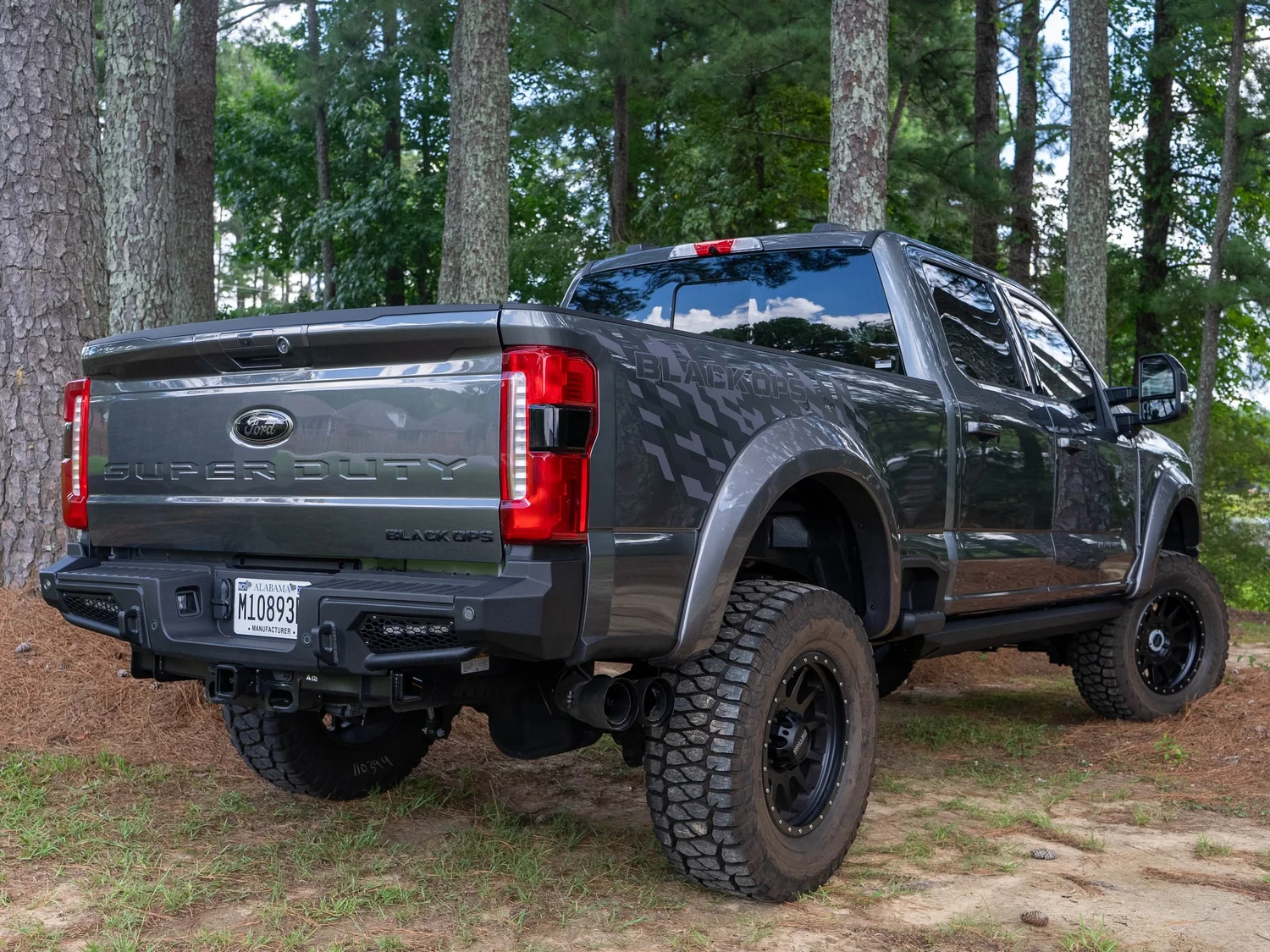 Rear three-quarter view of a lifted F-250 Super Duty Black Ops with blacked-out Super Duty tailgate and Black Ops side graphics