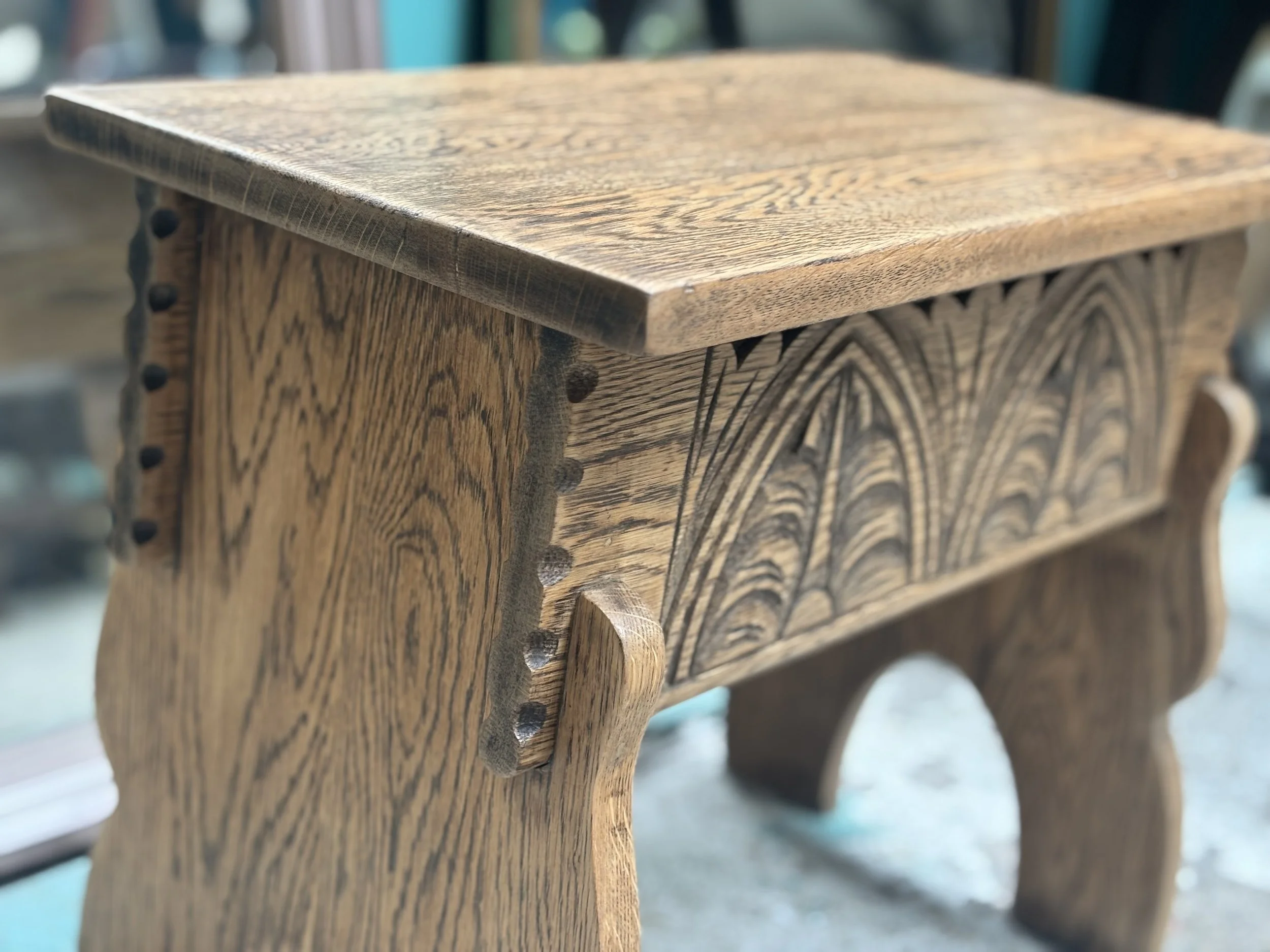 Close-up of a wooden bench with decorative carvings on the side panels.