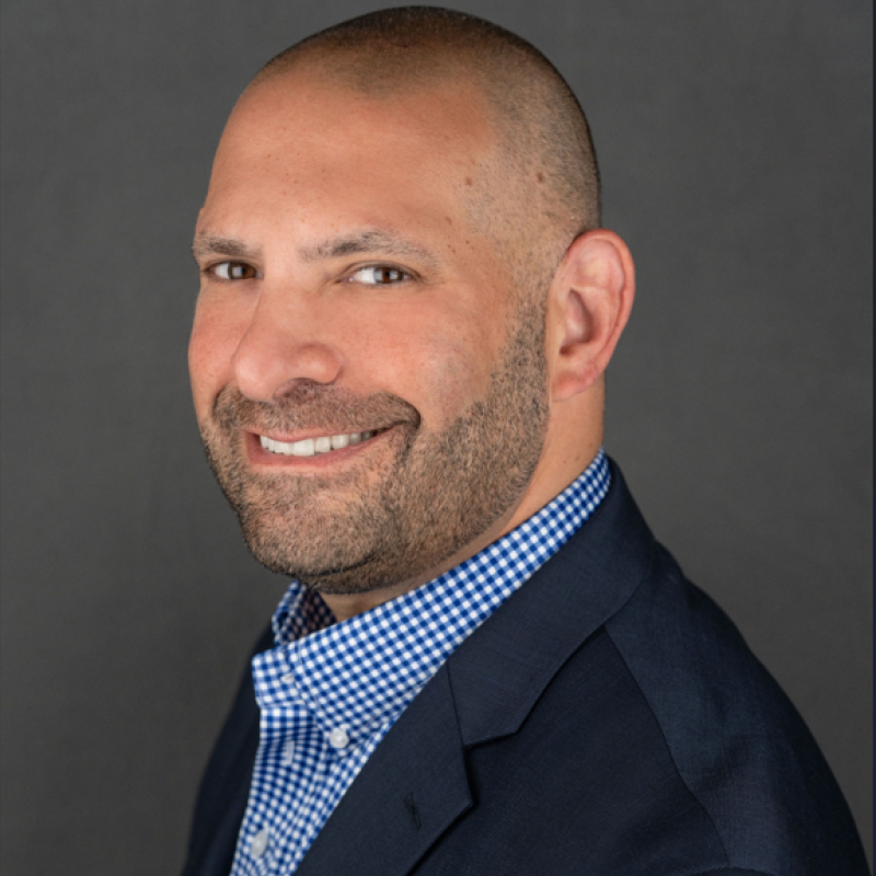 Ari Apirian, client of Rhythm Leadership, smiling in a blue shirt with sport jacket