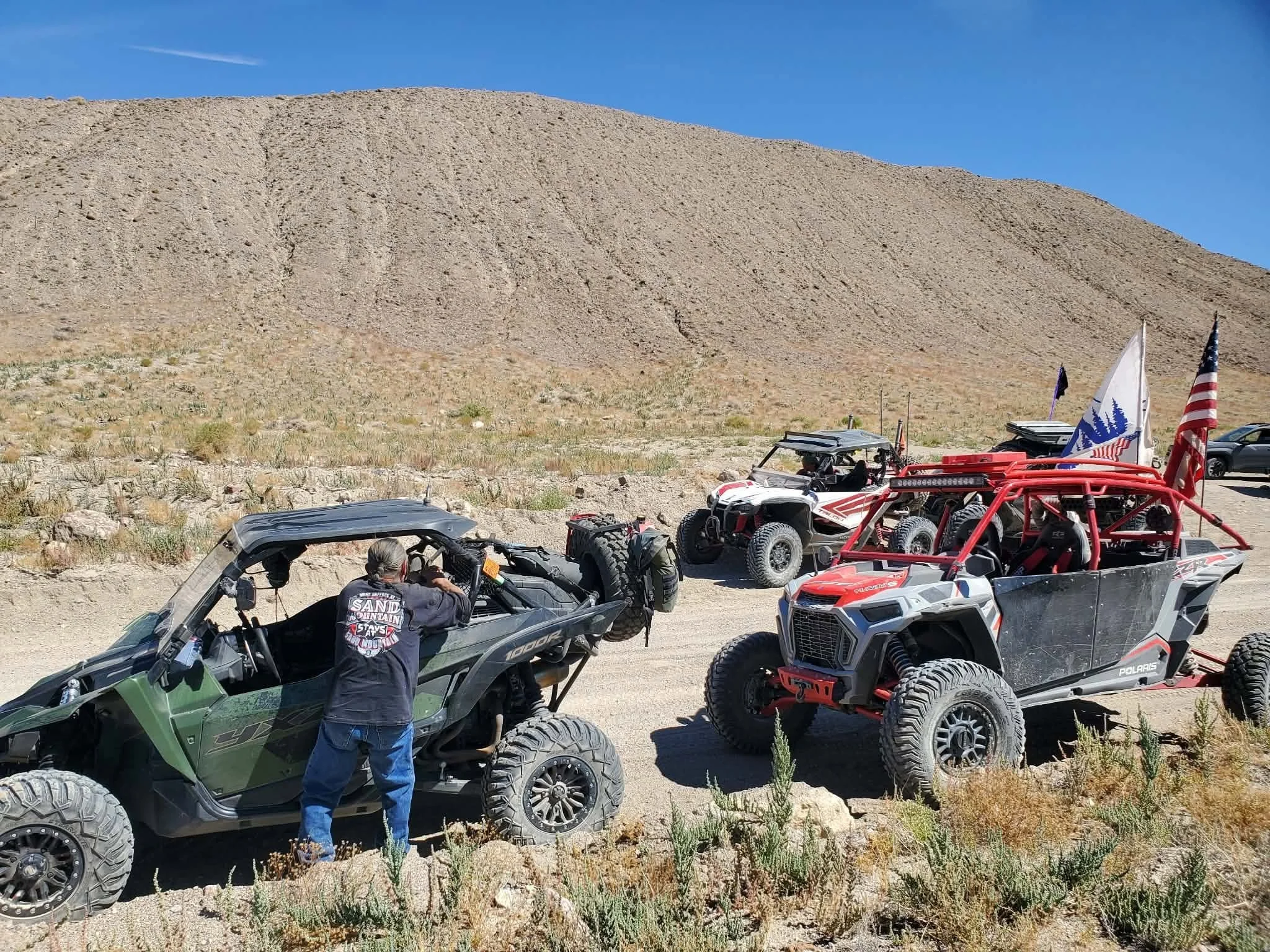 Custom-built off-road UTVs with American flags parked in the desert during the 2026 Dyer - Fish Lake Poker Run