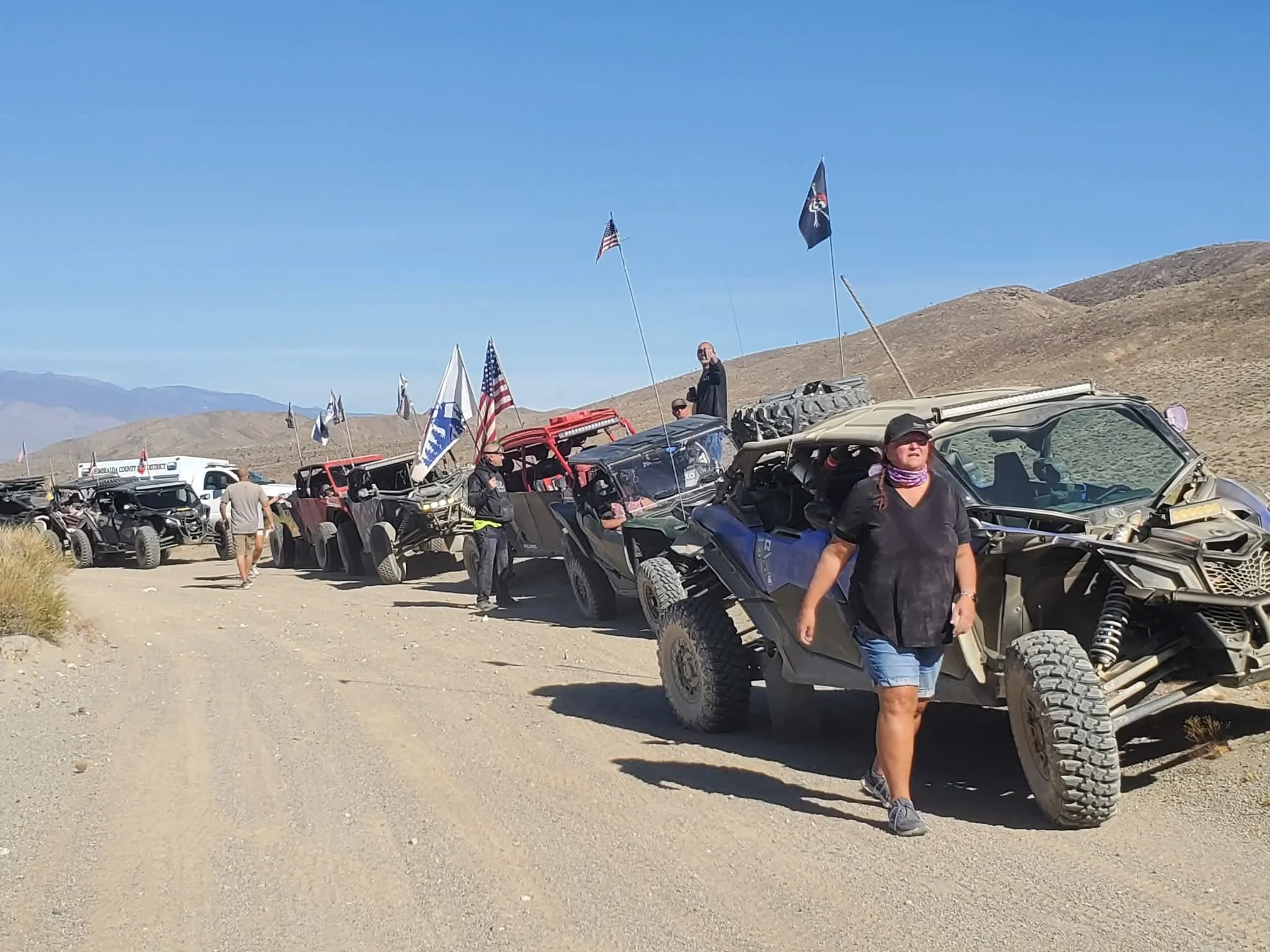 Rider standing beside a flagged off-road UTV on the trail during the 2026 Dyer - Fish Lake Poker Run