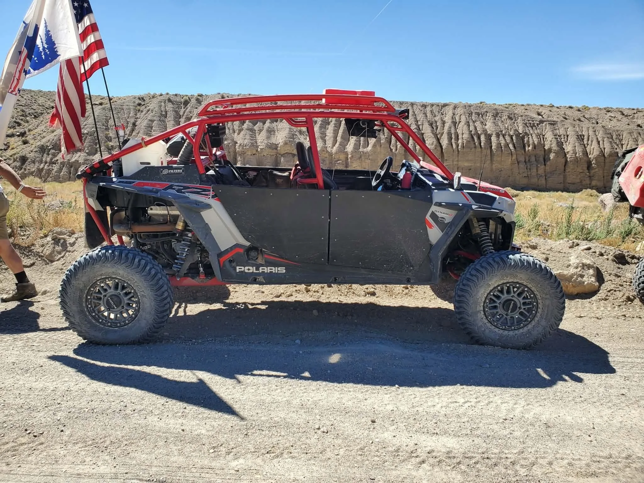 Custom red off-road UTV with an American flag staged for the 2026 Dyer - Fish Lake Poker Run