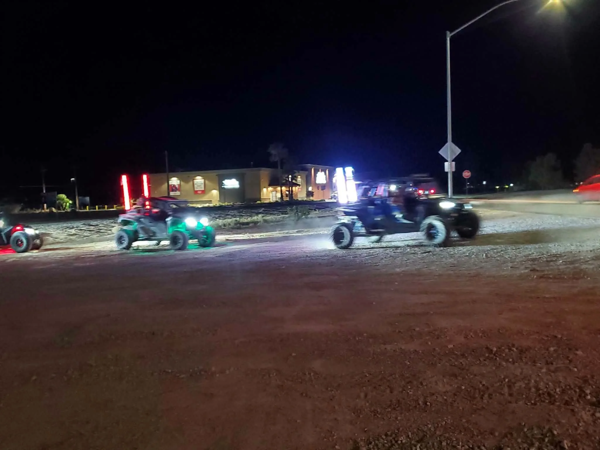 UTVs with colorful LED light bars riding at night through Pahrump, NV during the September 2026 Nye County SxS monthly meet