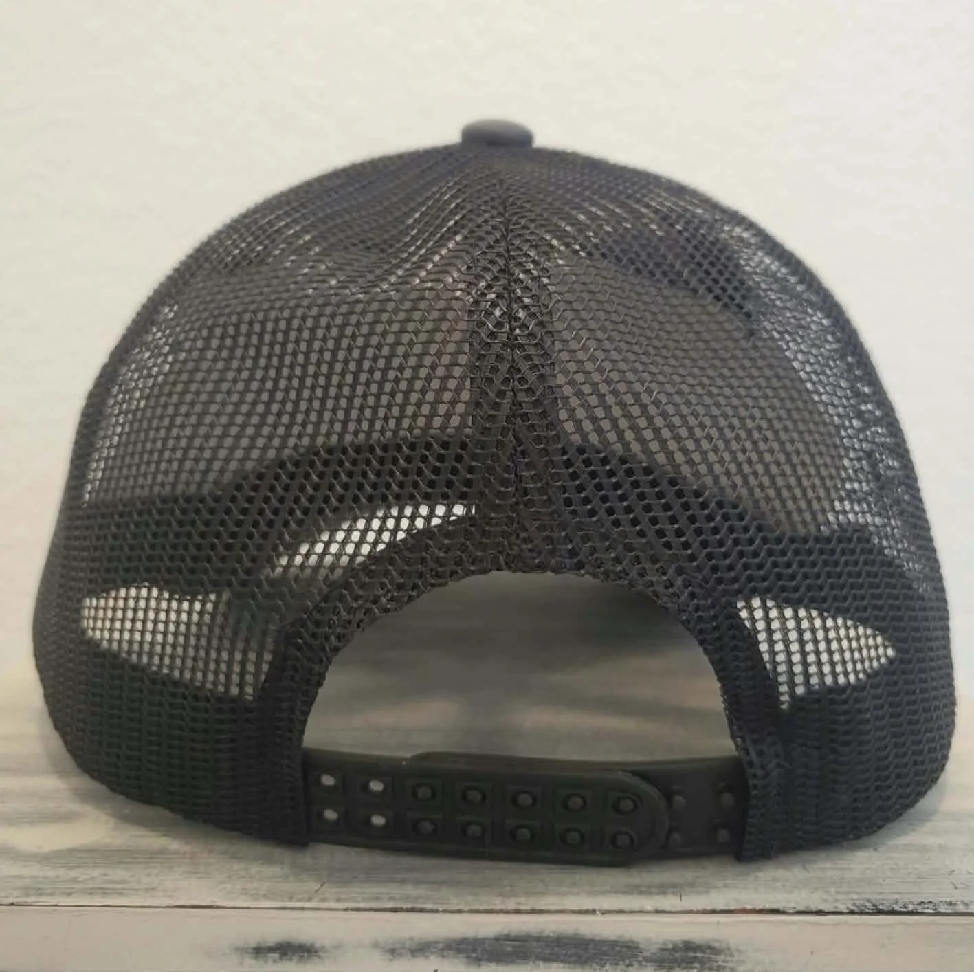 Black mesh back of Nye County SXS trucker hat, adjustable snapback closure