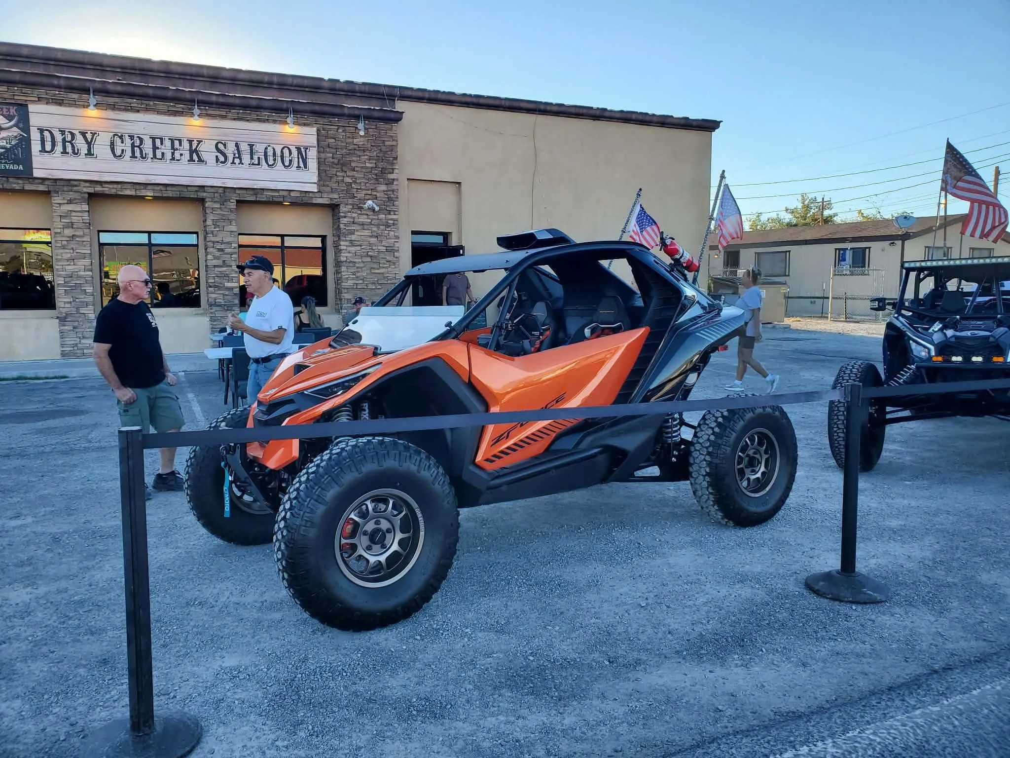Riders chatting beside an orange off-road UTV at the September 2026 Nye County SxS monthly meet