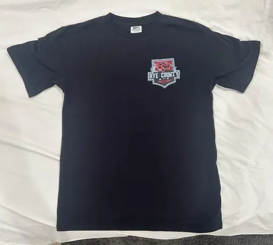 Black t-shirt front, left chest Nye County SXS off-road shield logo