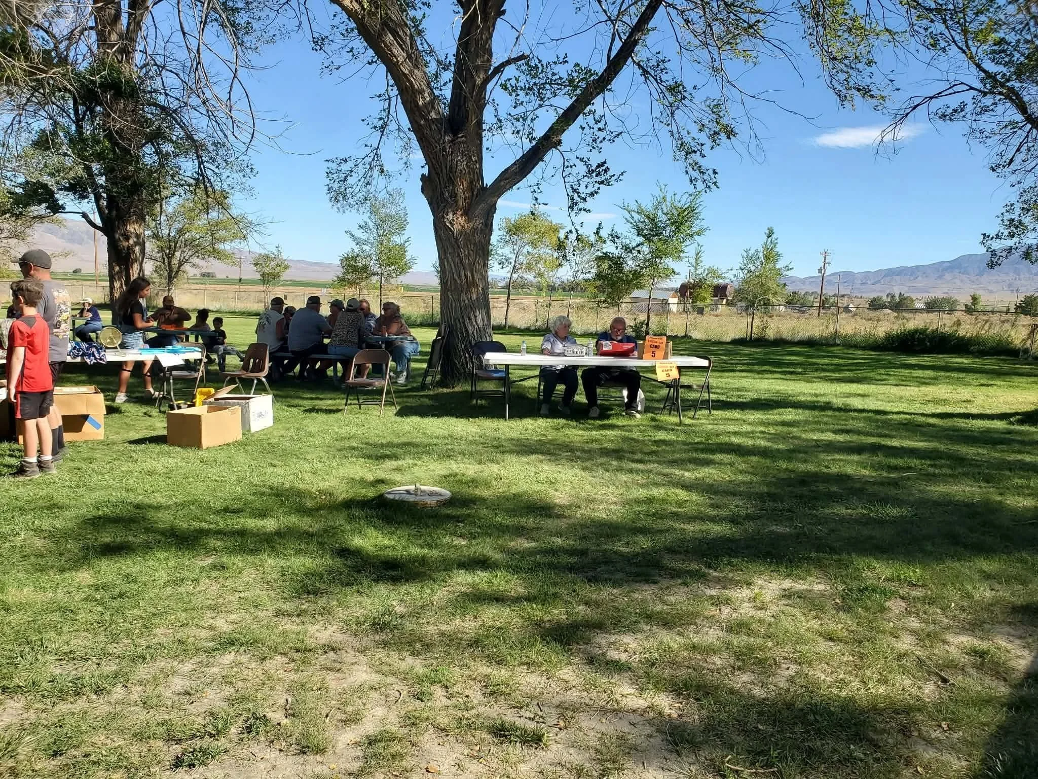 Participants checking in at the registration table on the lawn before the 2026 Dyer - Fish Lake Poker Run