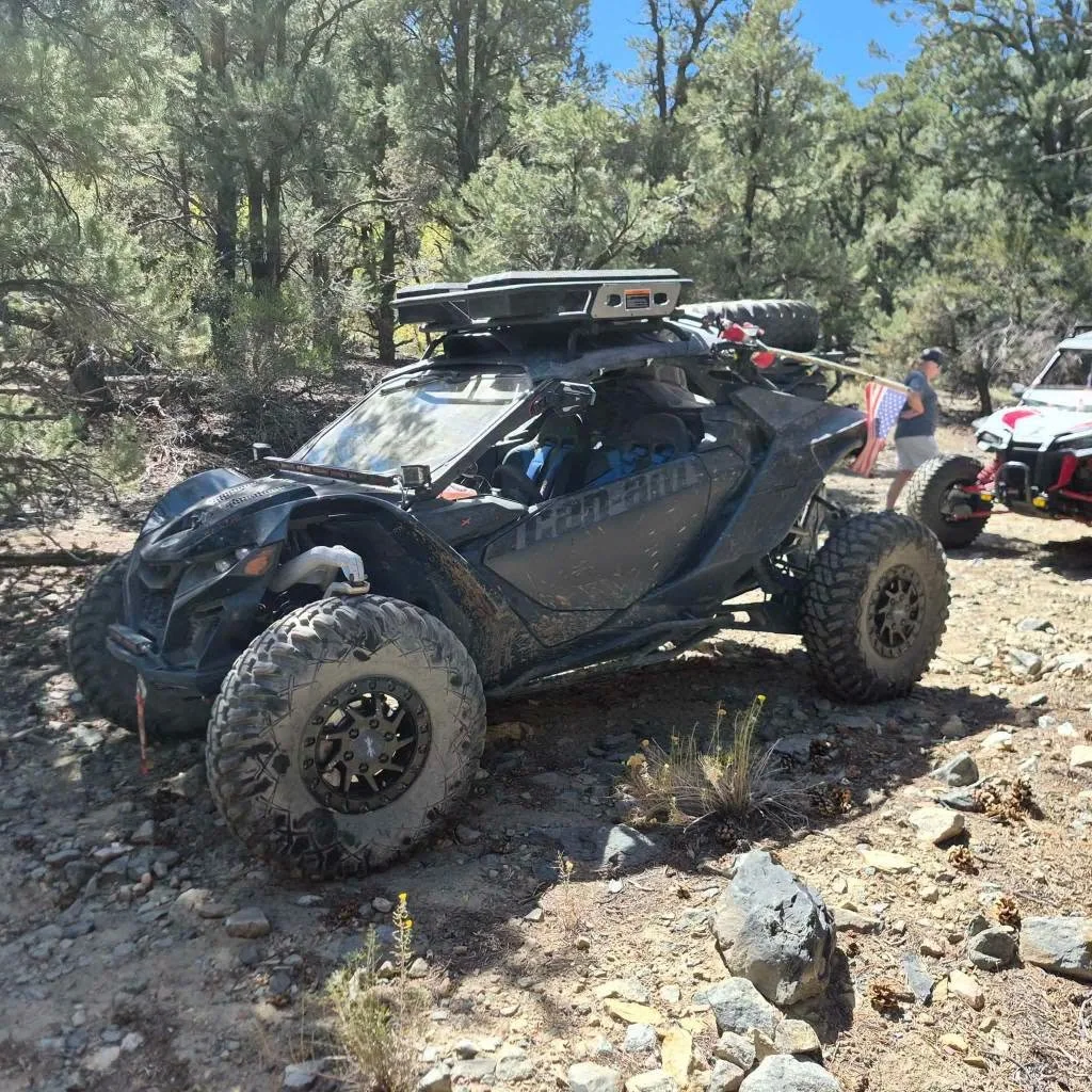 Off-road UTV parked among pinyon pine trees on the trail during the 2026 Dyer - Fish Lake Poker Run