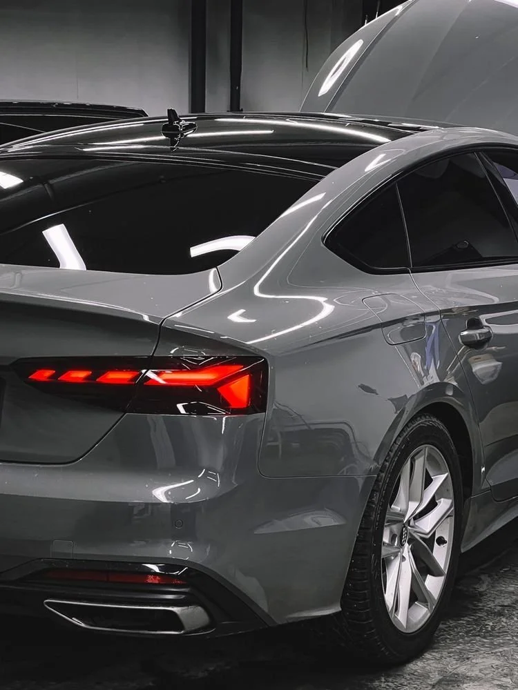 Voiture grise de luxe vue de l'arrière dans un parking intérieur.