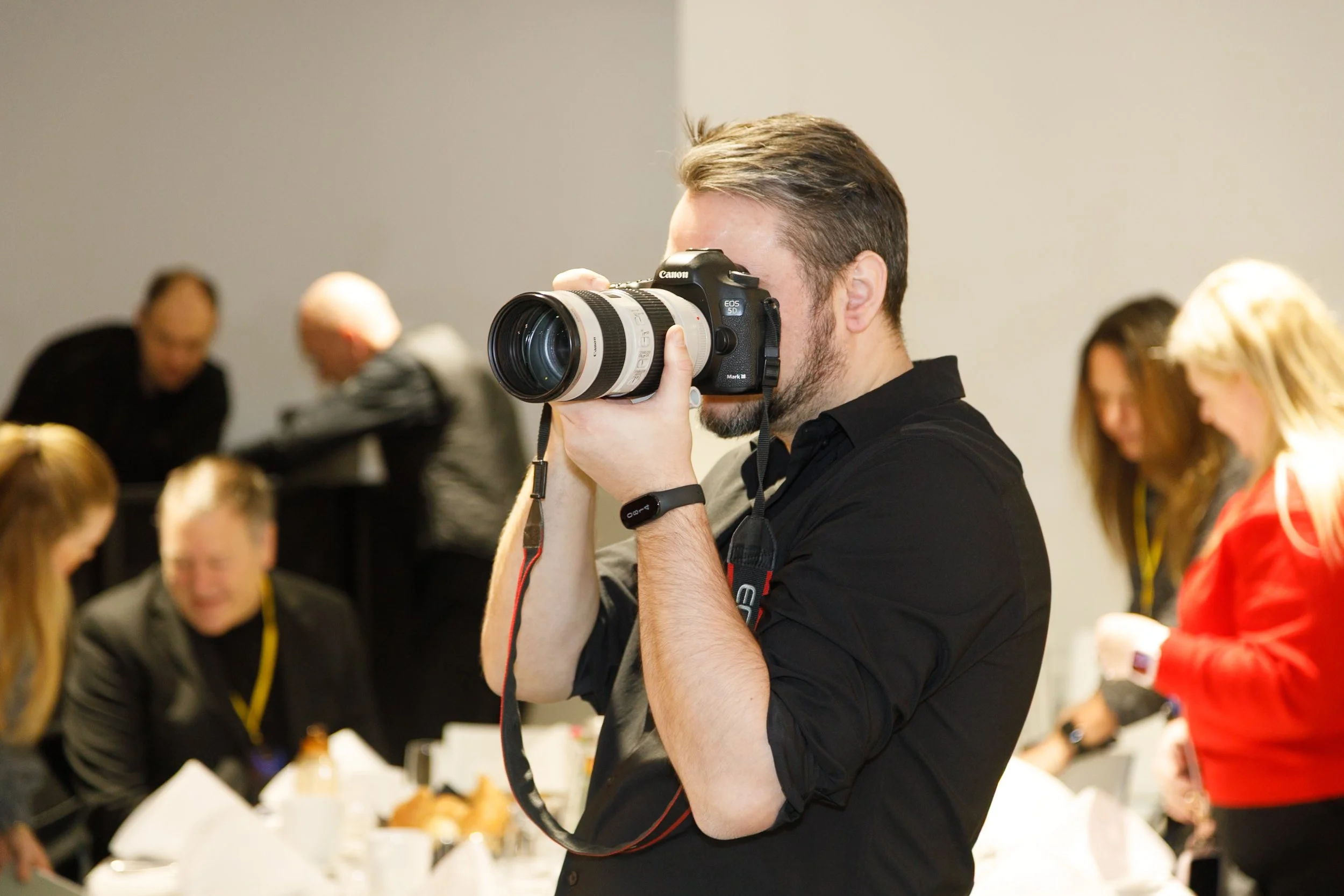 Event photographer covering a conference with professional camera gear.