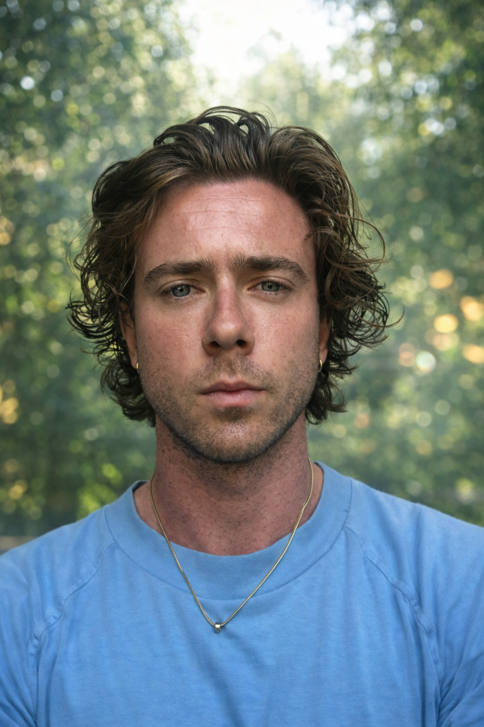 Smiling woman with shoulder-length blonde hair, wearing a black top and a necklace, indoors with warm lighting.