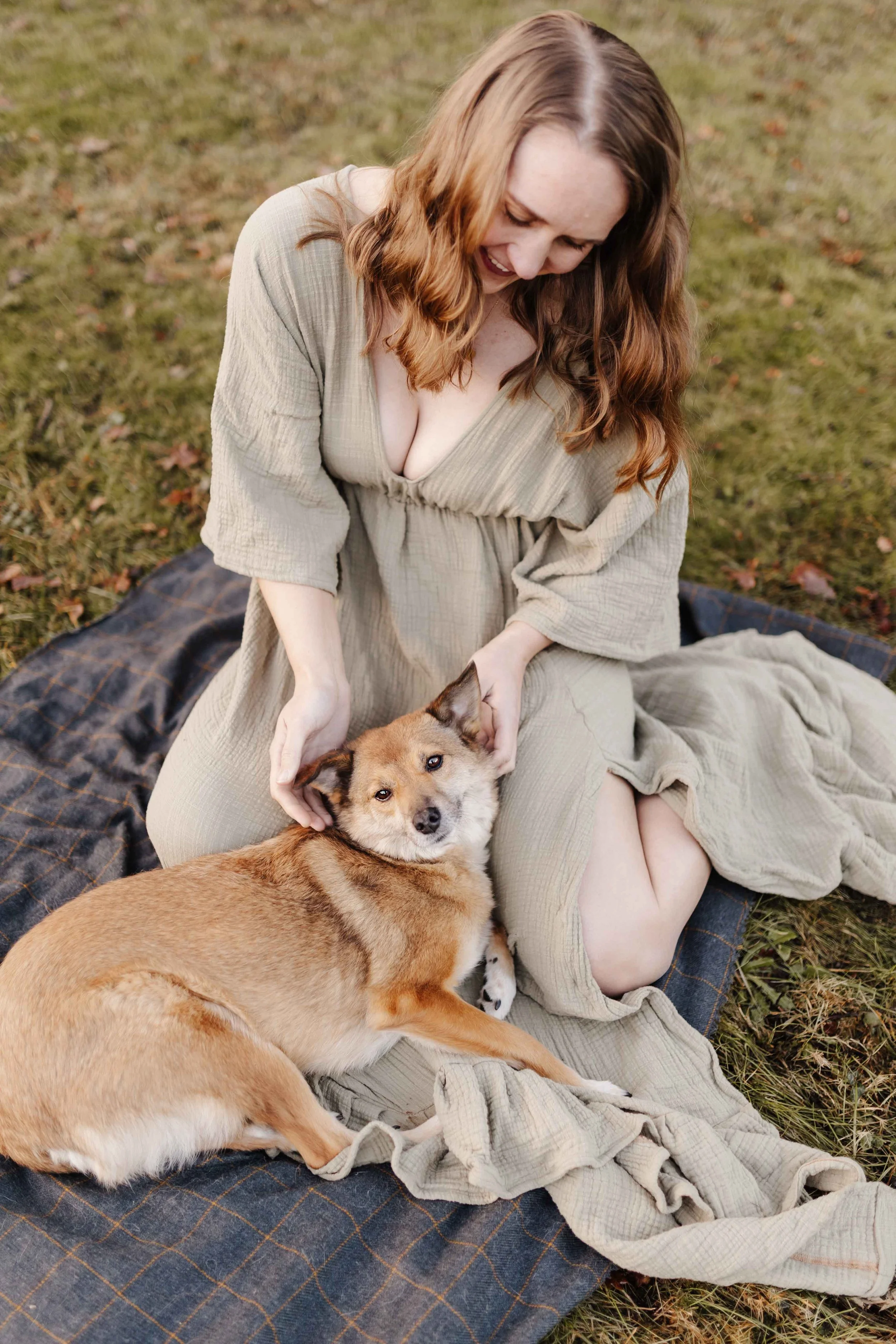 Frau im oliven Kleid mit Hund auf einer Decke