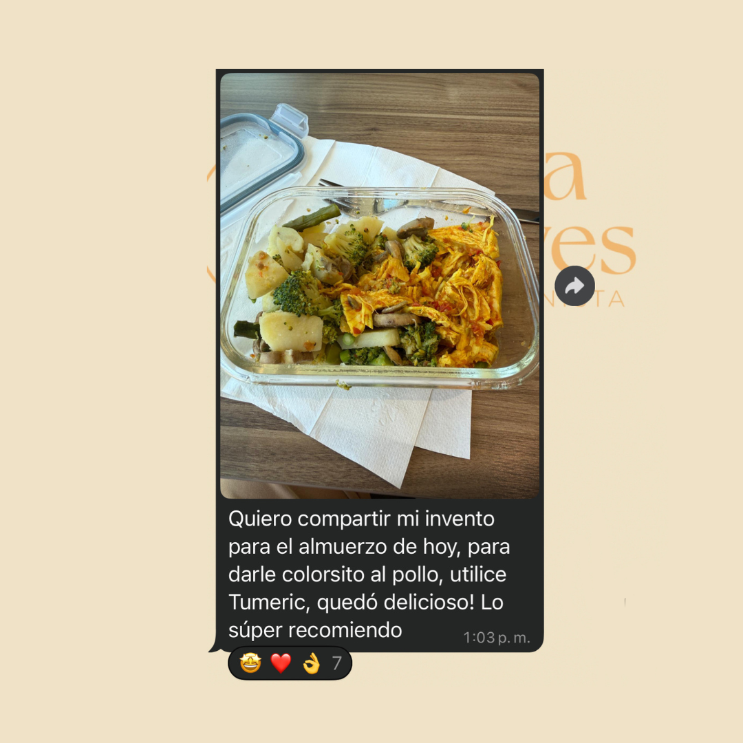 Plato de comida con verduras como brócoli, papas, y un pollo con salsa amarilla, sobre una mesa de madera con una servilleta debajo.