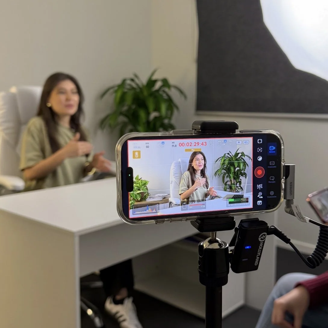 Luisa Cleves Nutricionista hablando en una entrevista grabada en una cámara con fondo de plantas y paredes blancas.
