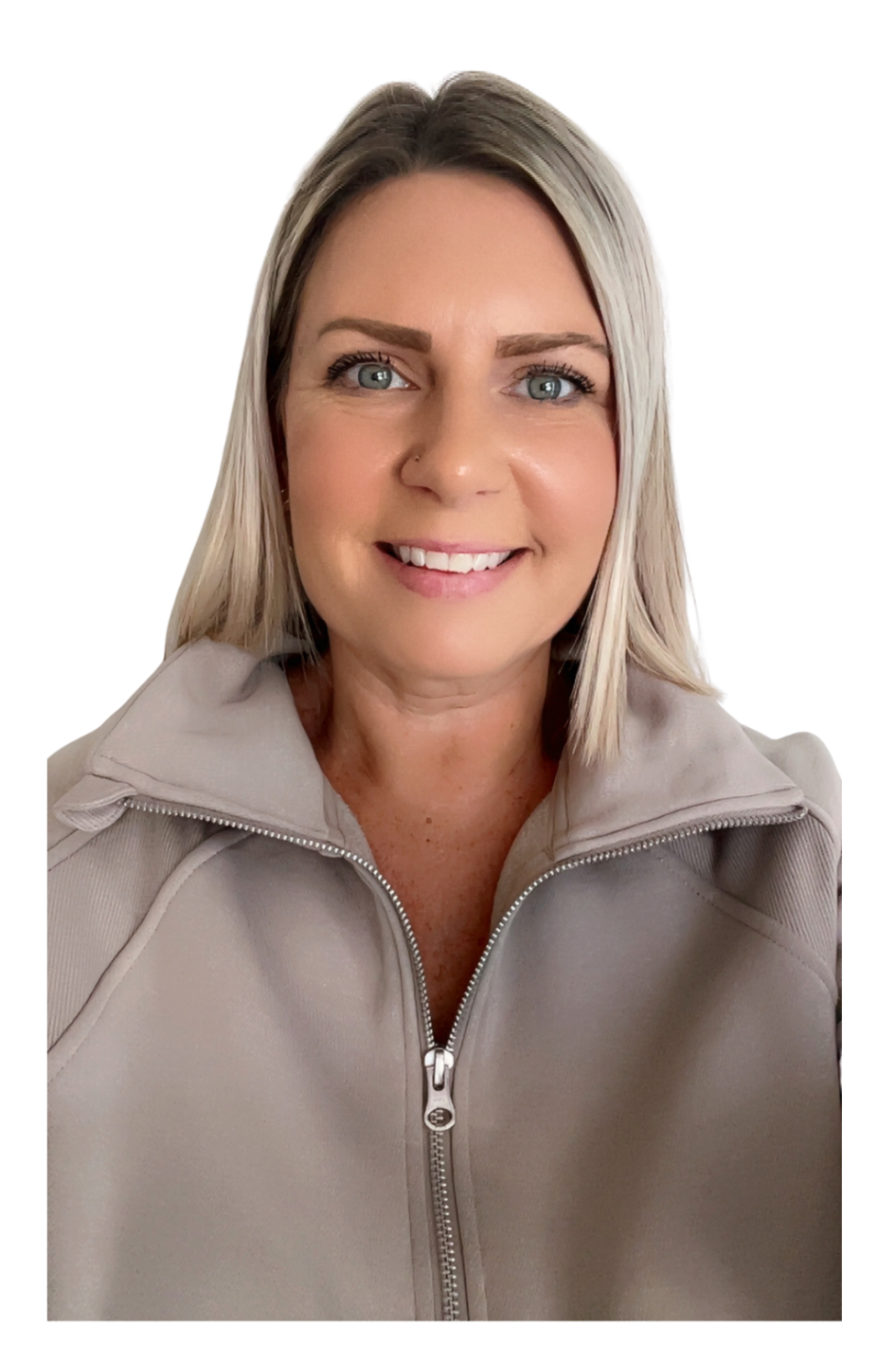 A woman with blonde hair smiling at the camera, wearing a light gray zip-up jacket with a neutral indoor background.