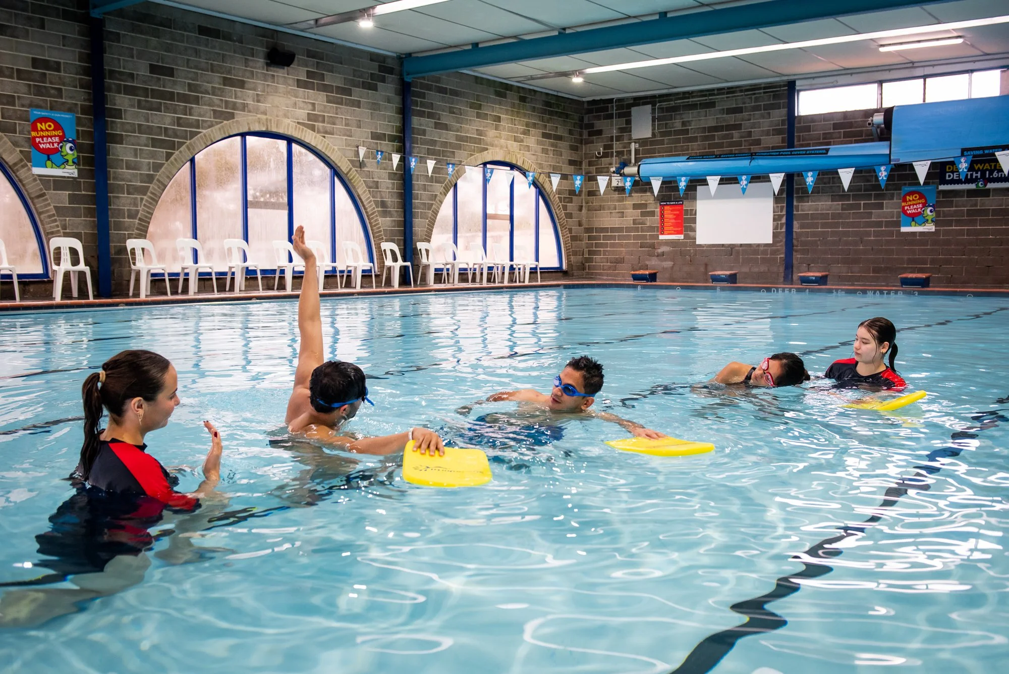 Swimming lesson with four children and an instructor in an indoor pool