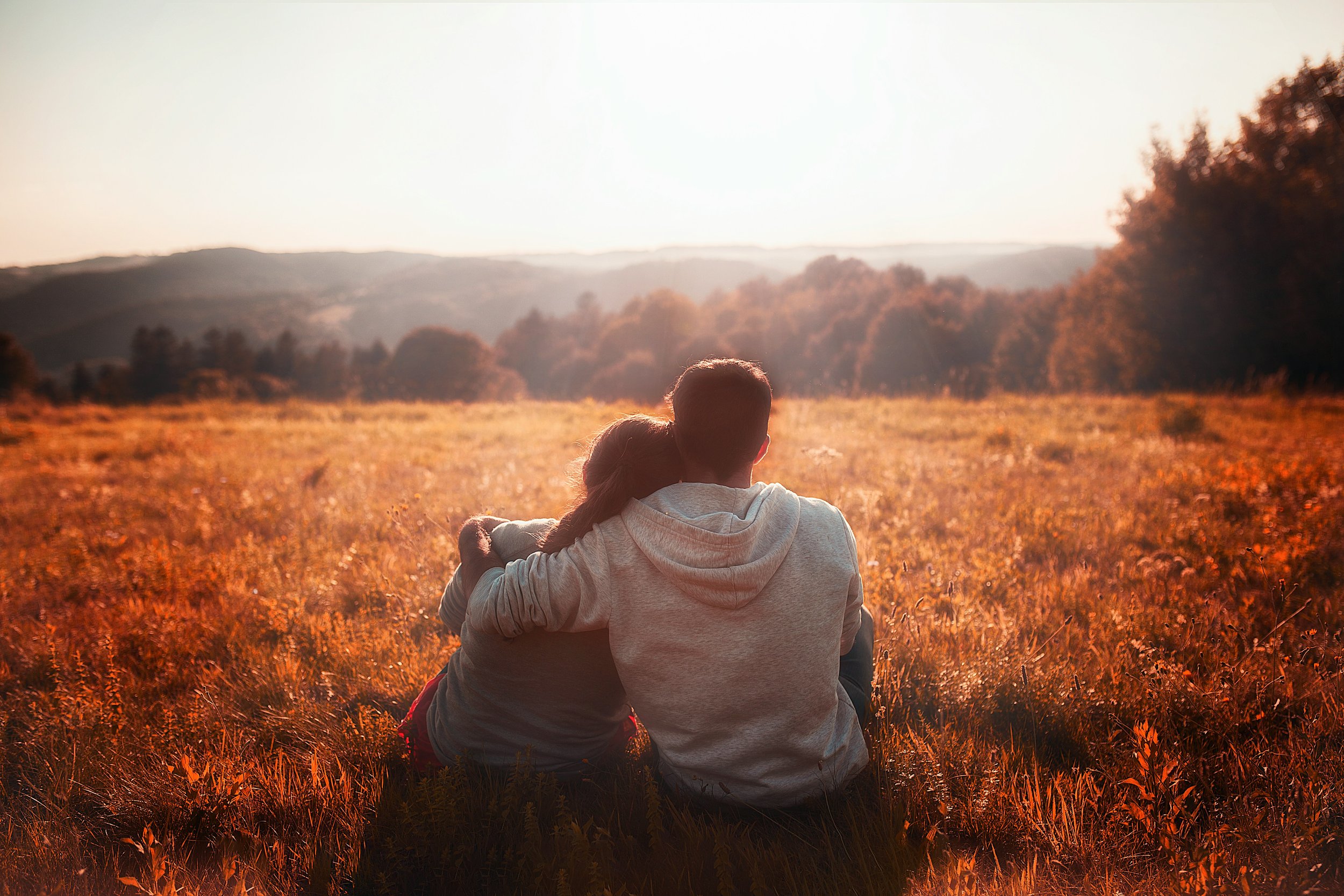 Silhouette of two partners with foreheads touching at sunset, representing ketamine assisted couples therapy